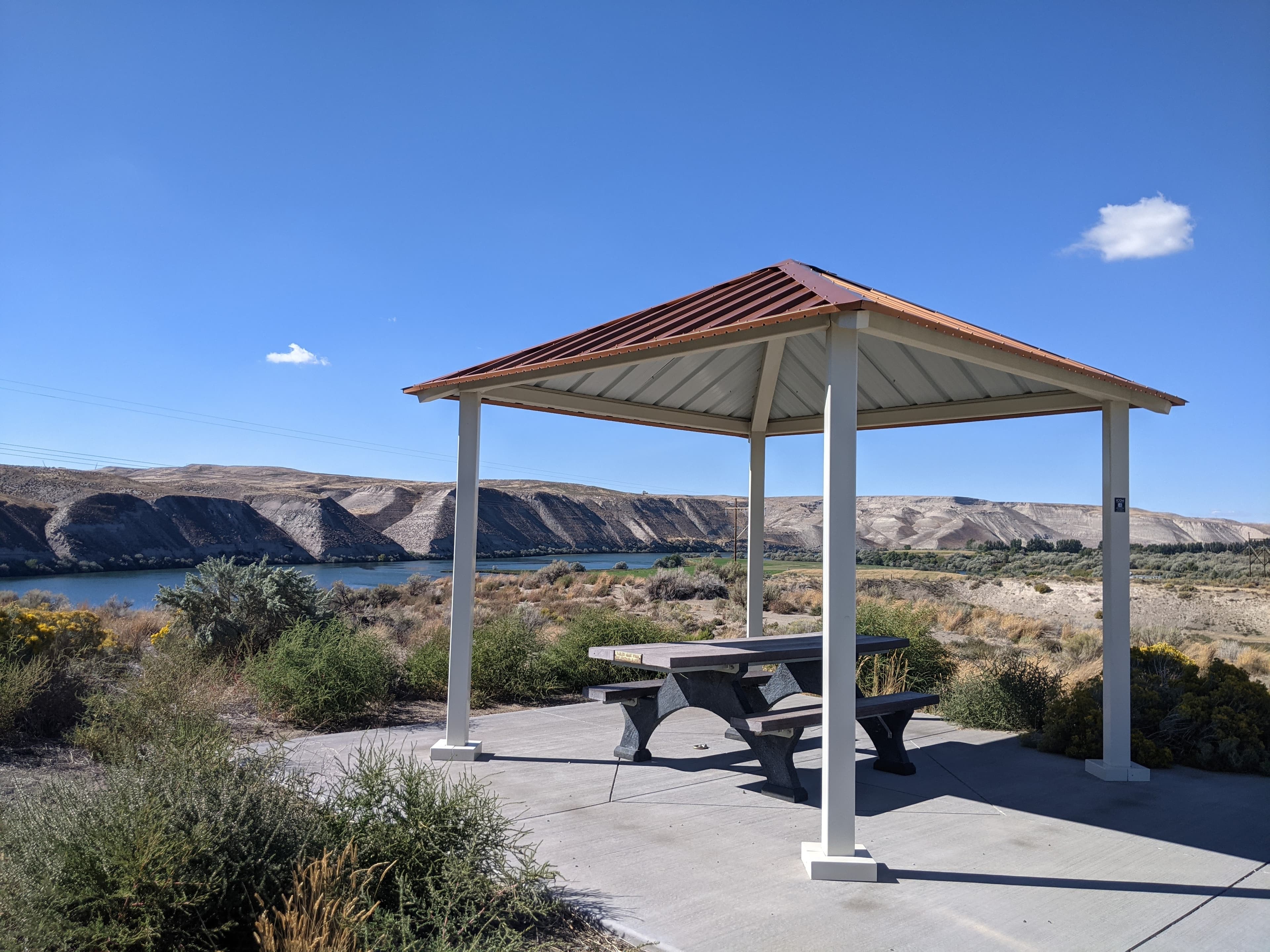 A picnic table under a shelter overlooks the Snake River.
