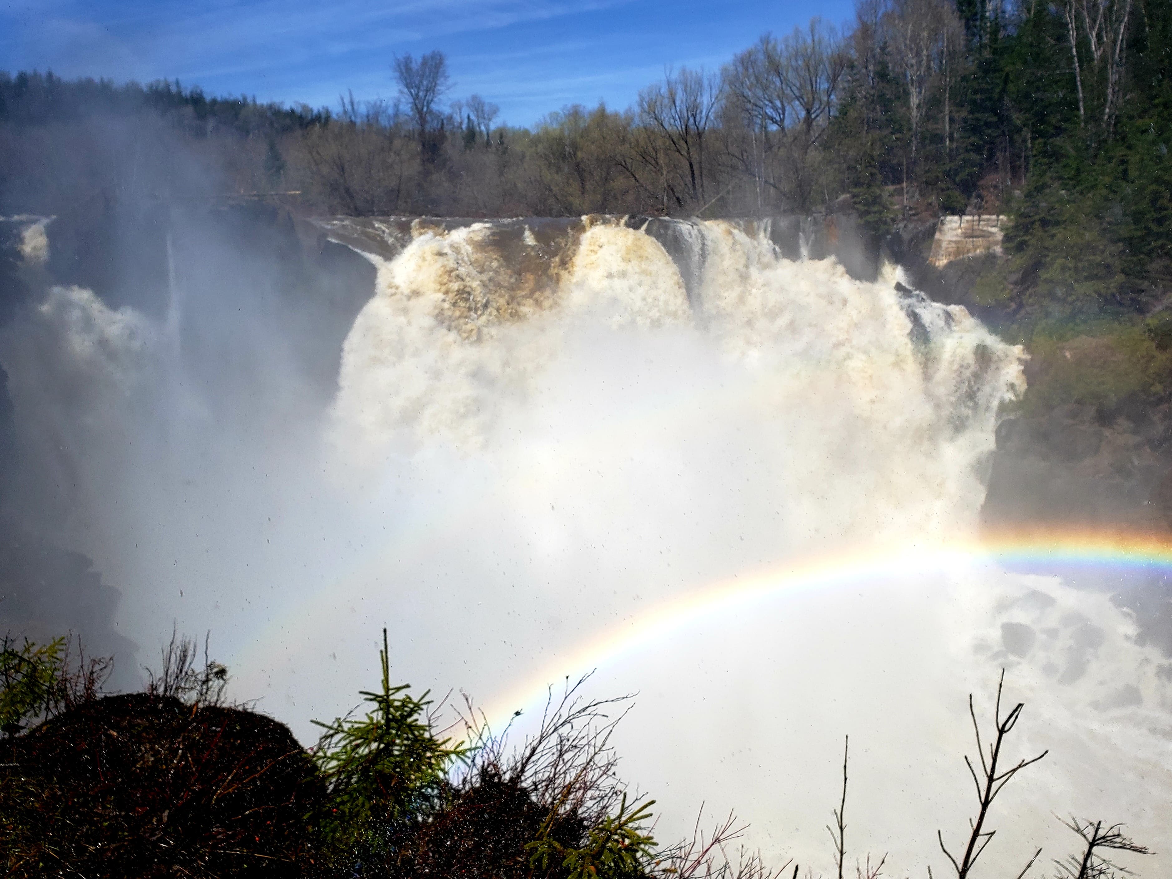 A waterfall with a rainbow in front