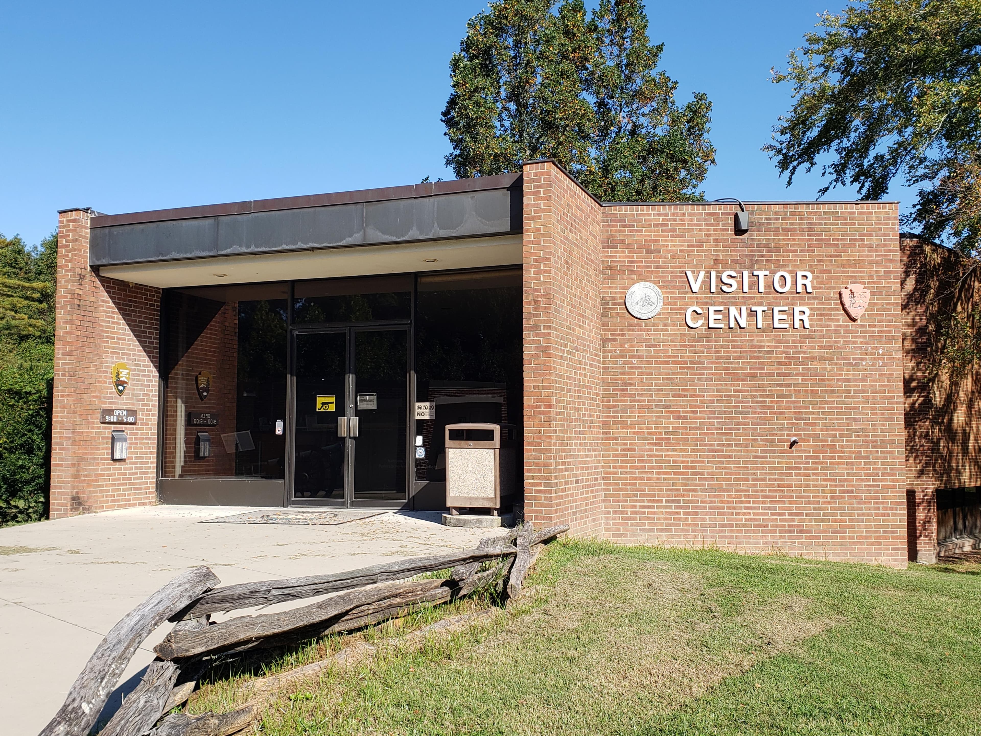 A look at the front of the brick visitor center under a cloudless blue sky.