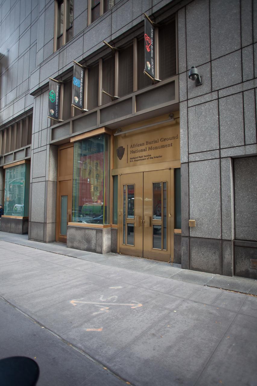 Brass entrance doors to the Visitor Center with flags flying above