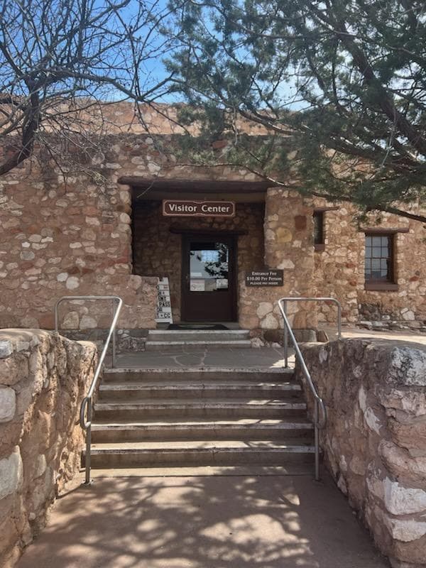 Steps lead up to a door in a stone building with a sign that reads, Visitor Center.