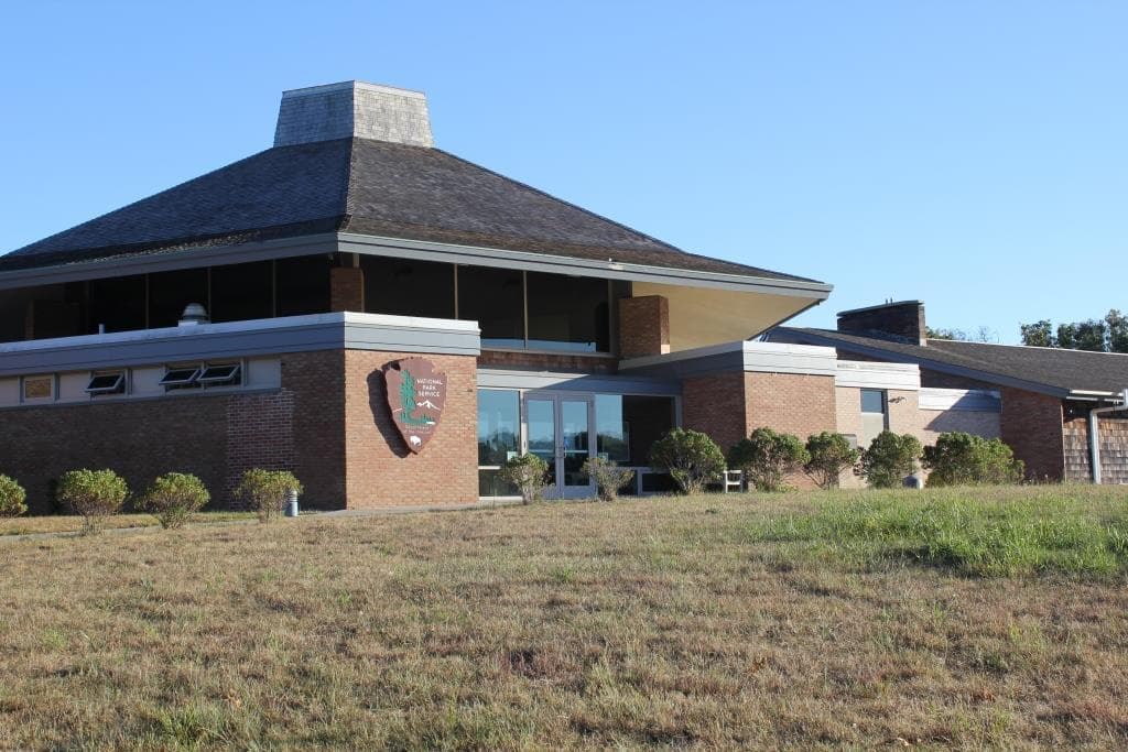 A large brick and glass building with tall roof.