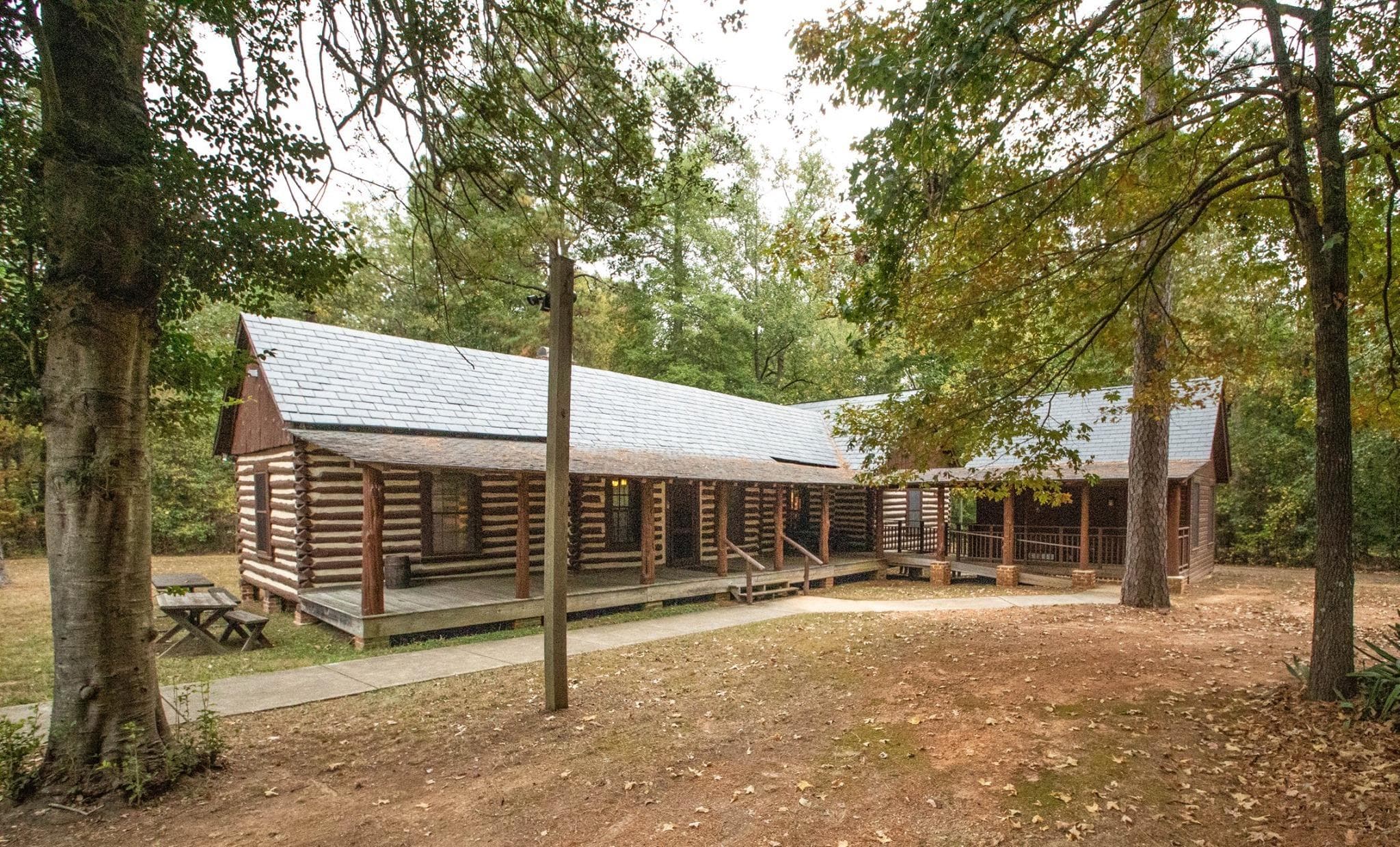 A log cabin with a wooden porch in the woods.
