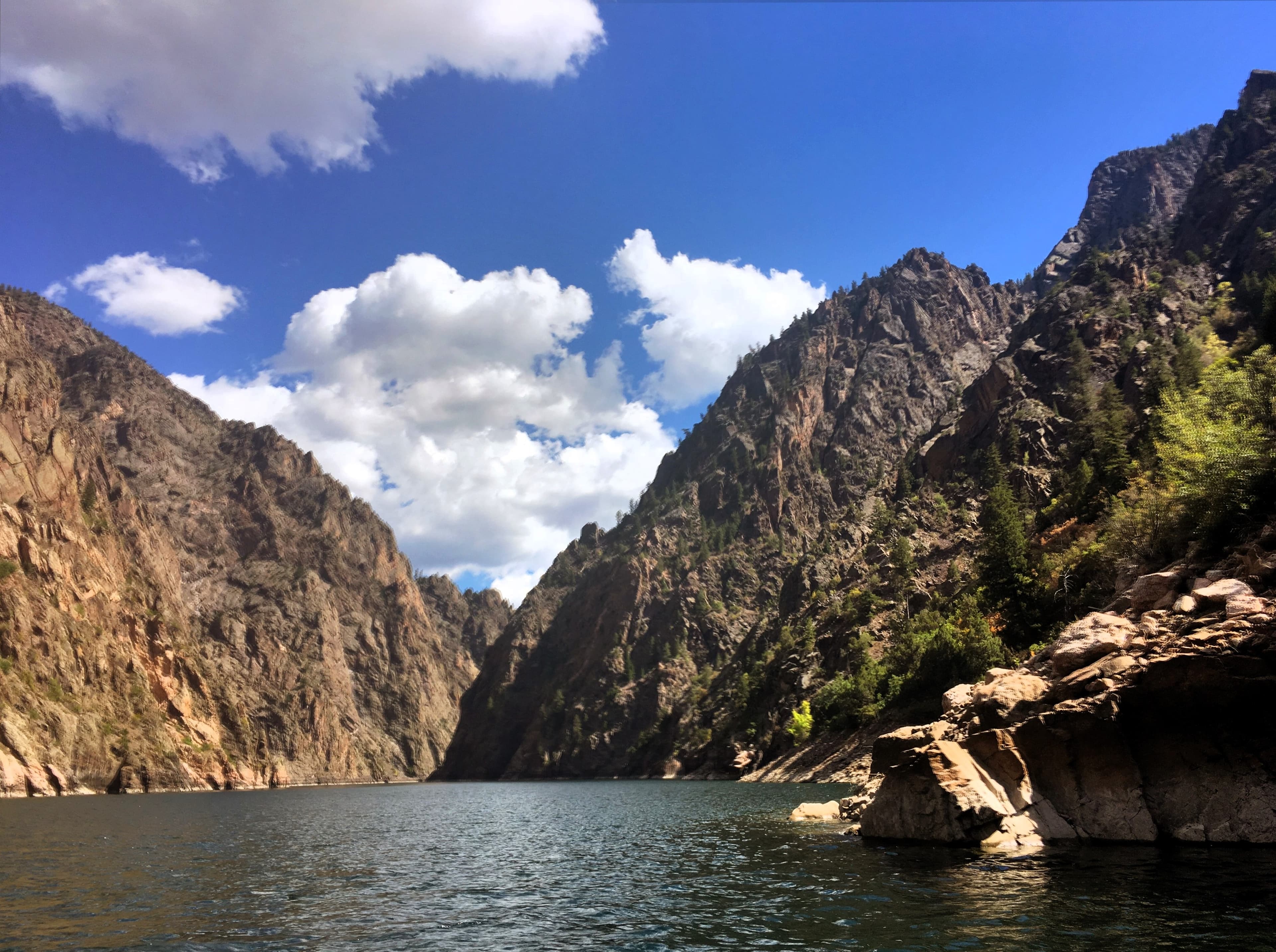 Tall canyon walls and rocky shoreline along a reservoir