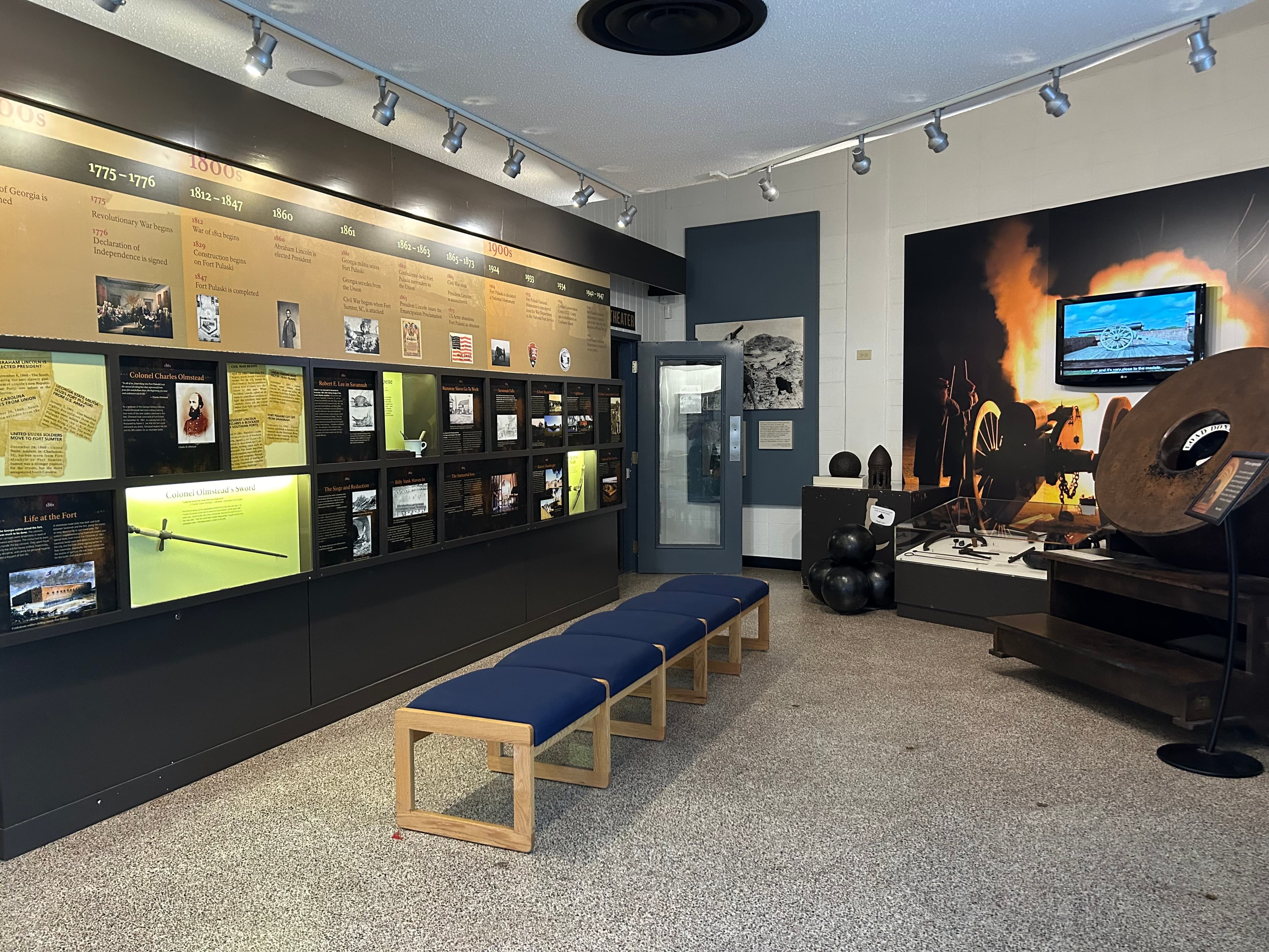 Museum with information panels on the left and cannon artifacts on the left.