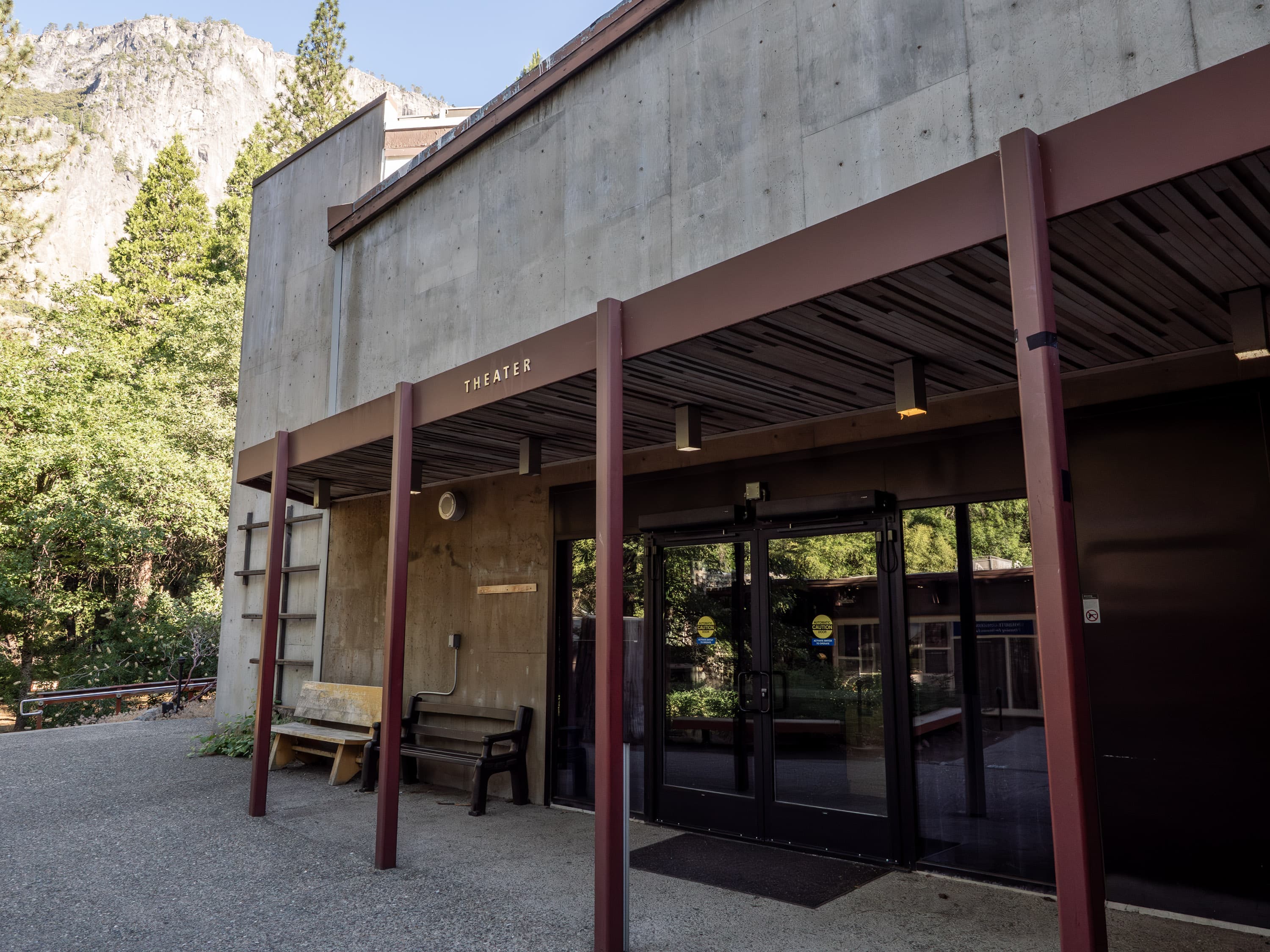 A covered entryway leads to glass double doors; lettering above the entryway reads "theater"