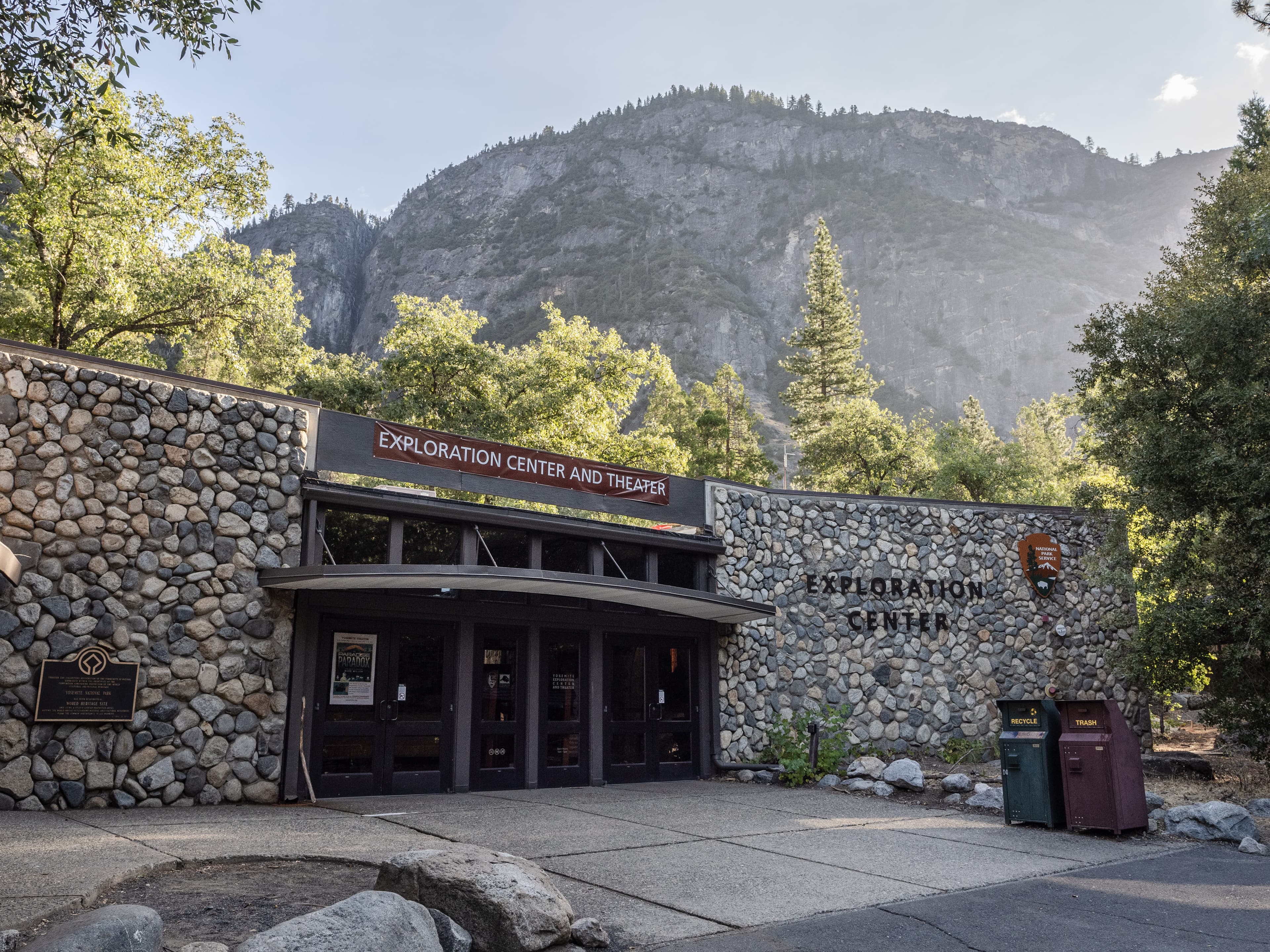 A building with glass double doors and river rock walls surrounding both sides