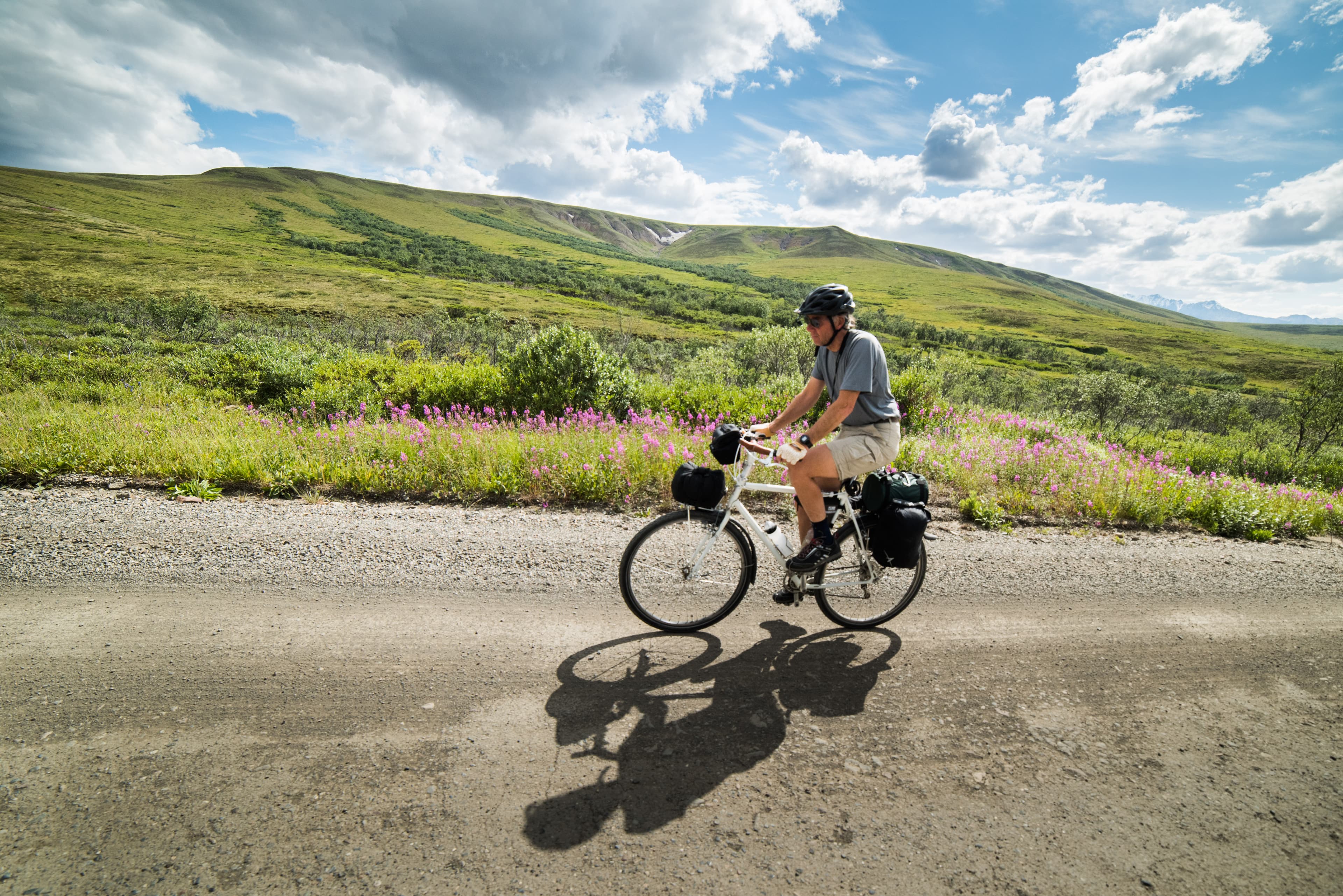a person riding a bicycle on a dirt road