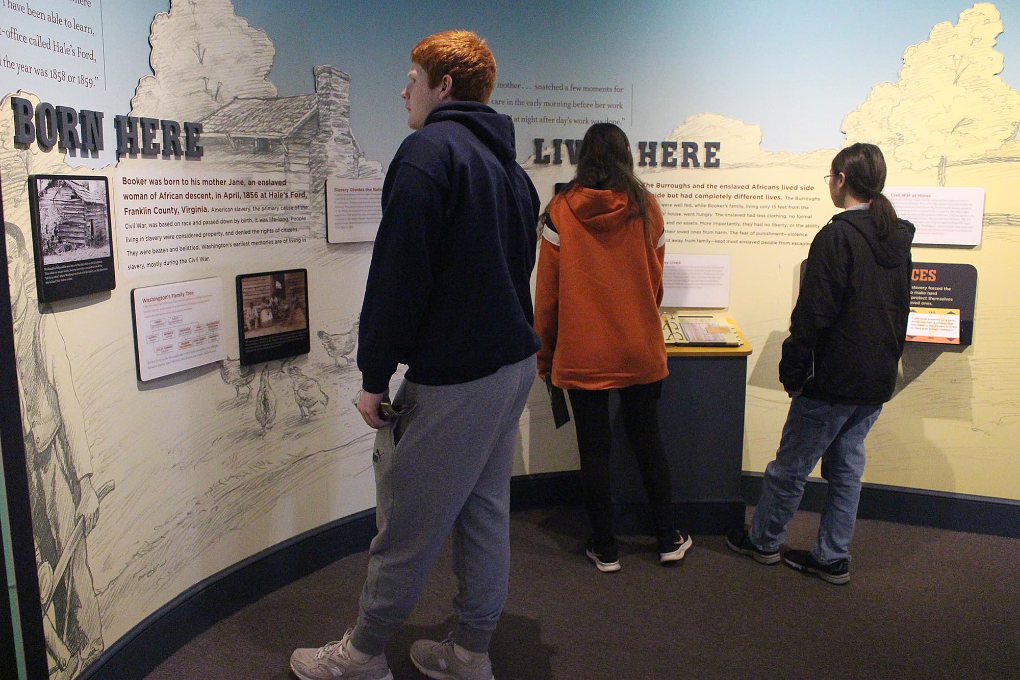A group of visitors reading at an exhibit