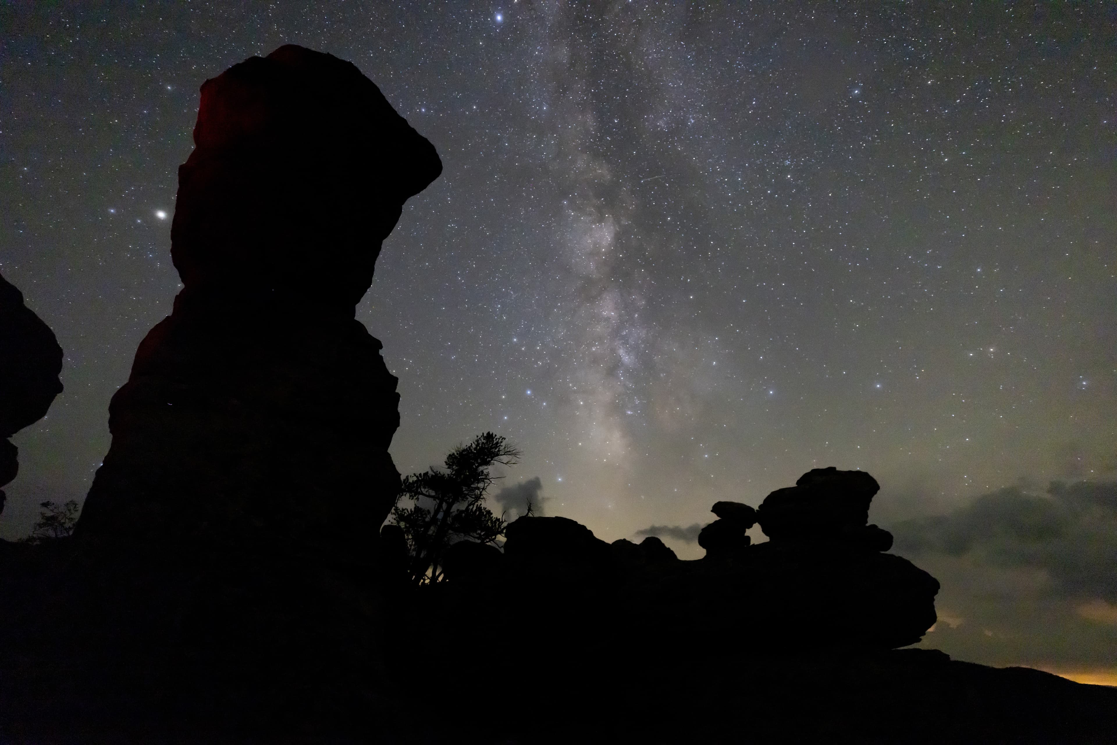 stars and milky way above a large rock formation