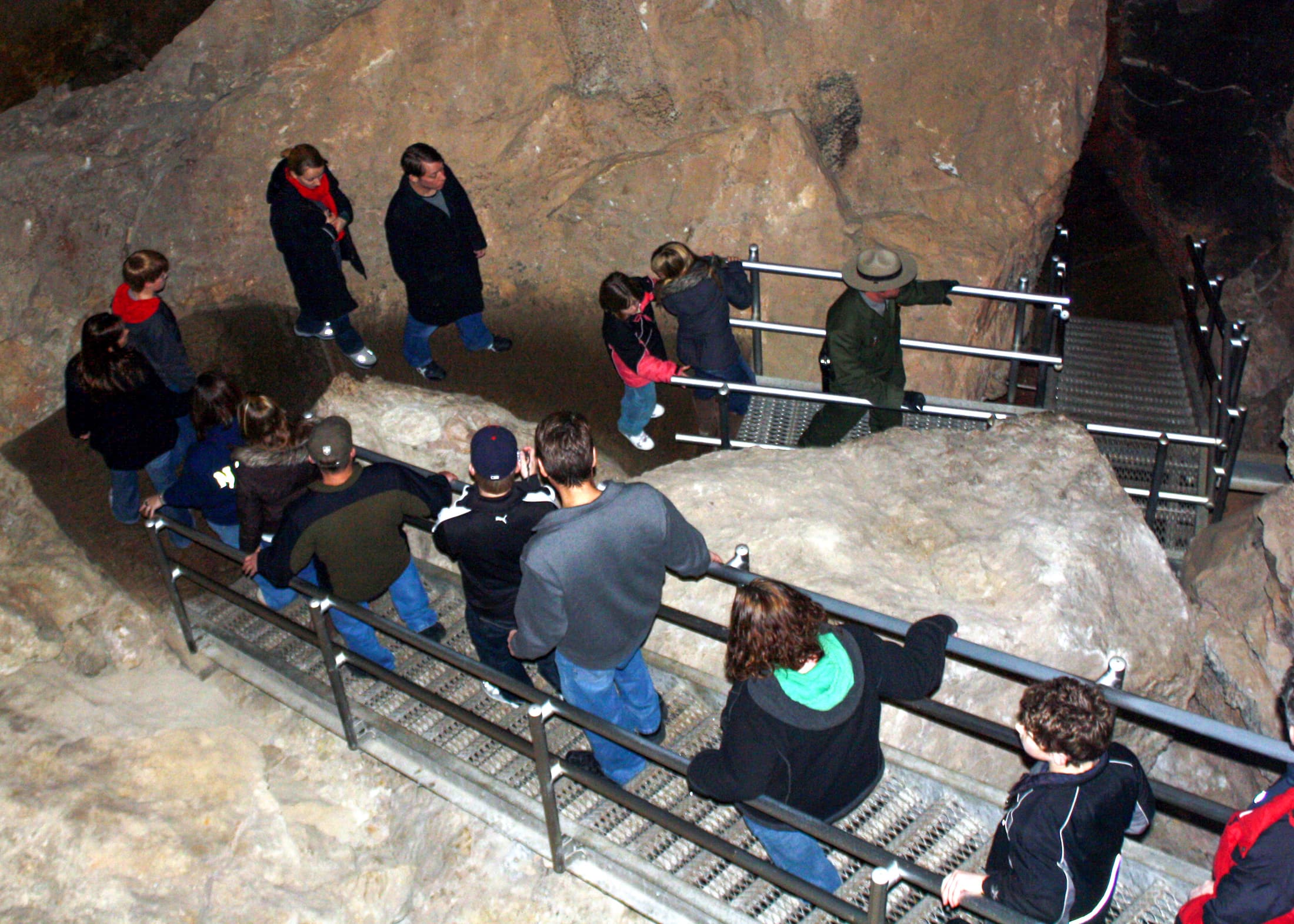 Ranger leading people down stairs during cave tour.