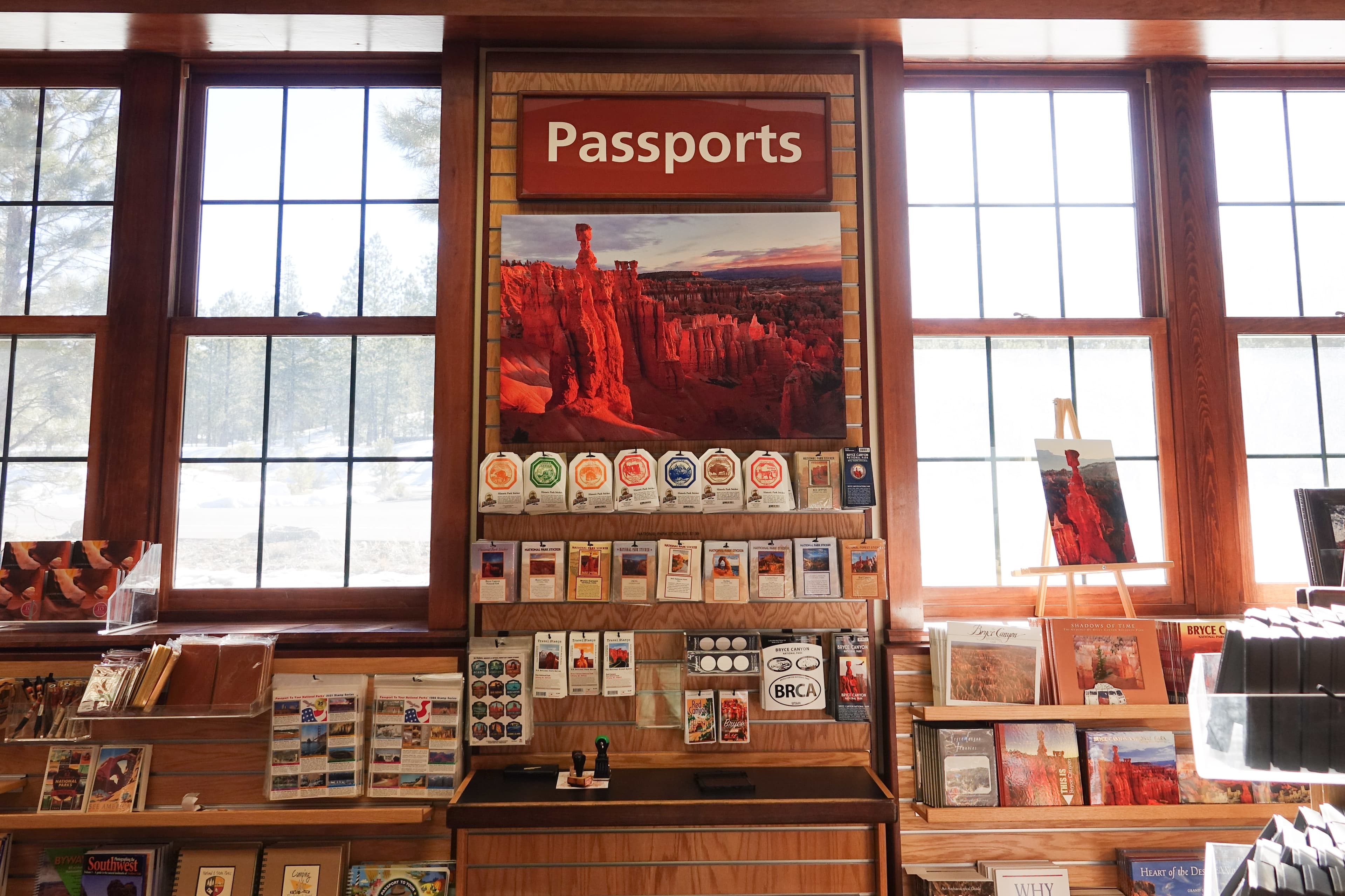 A merchandise display between two windows reads Passports with many stickers and stamps.