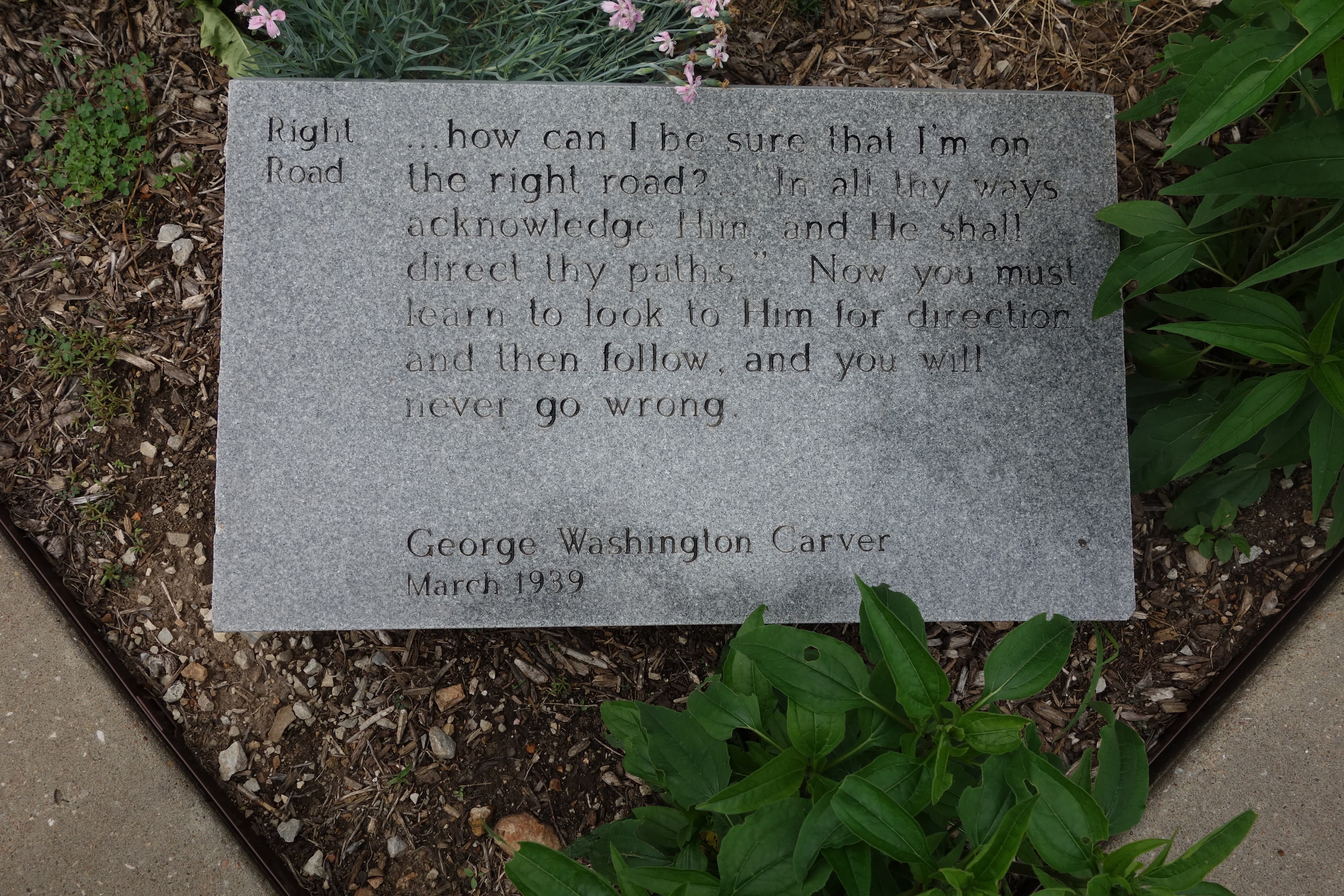 A stone granite GW Carver quote outdoor panel.