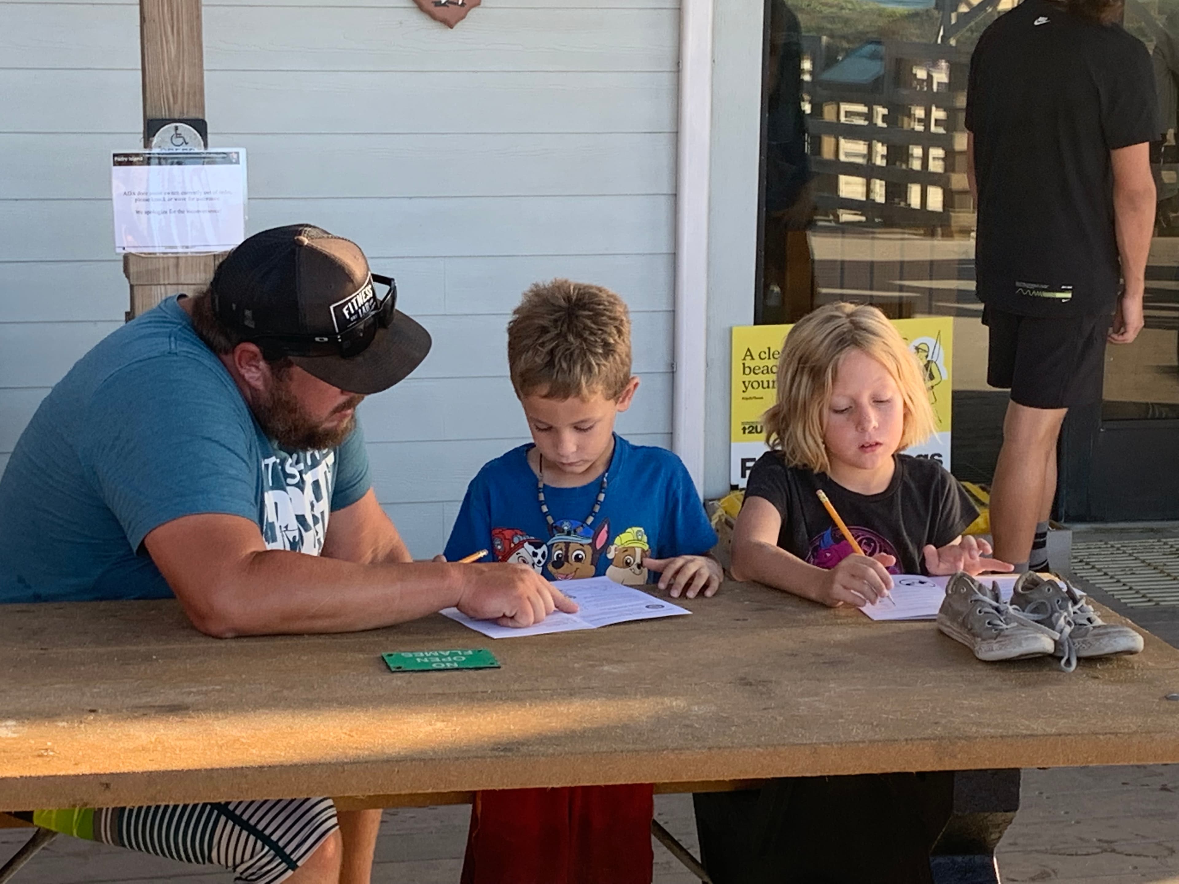 A parent helping with a Junior Ranger book.