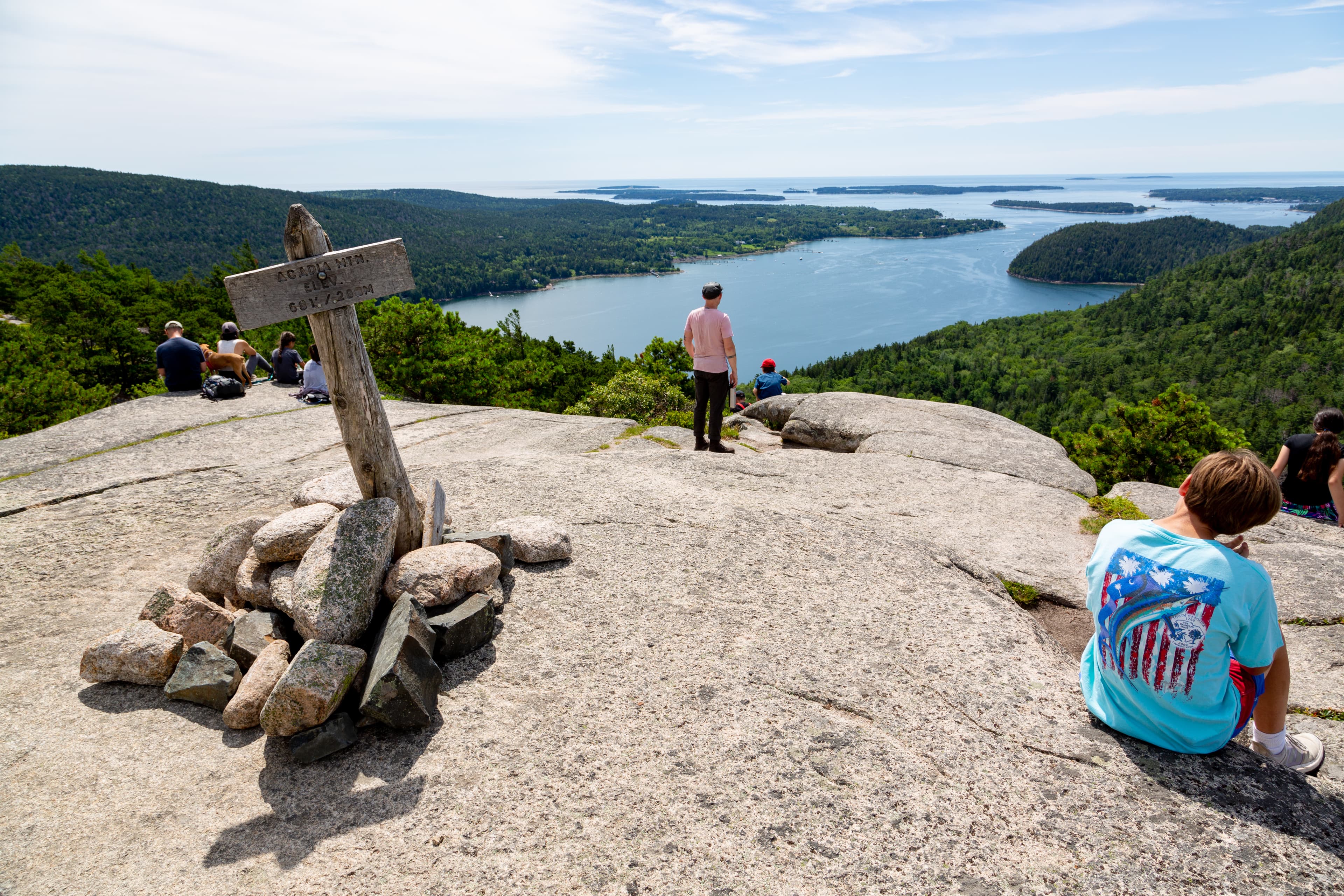 Visitors overlook islands from a mountain summit
