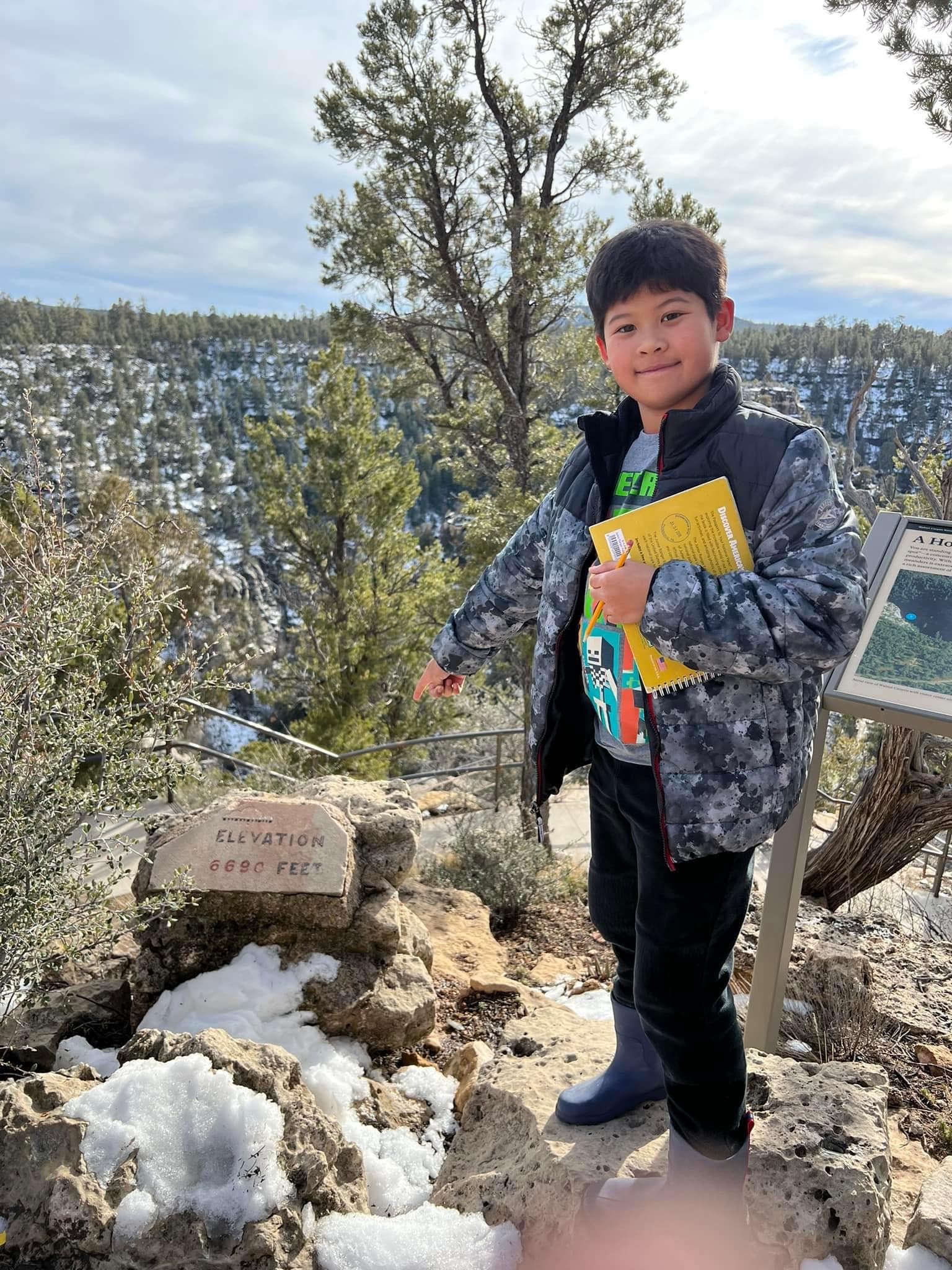 A child stands on a trail above Walnut Canyon.