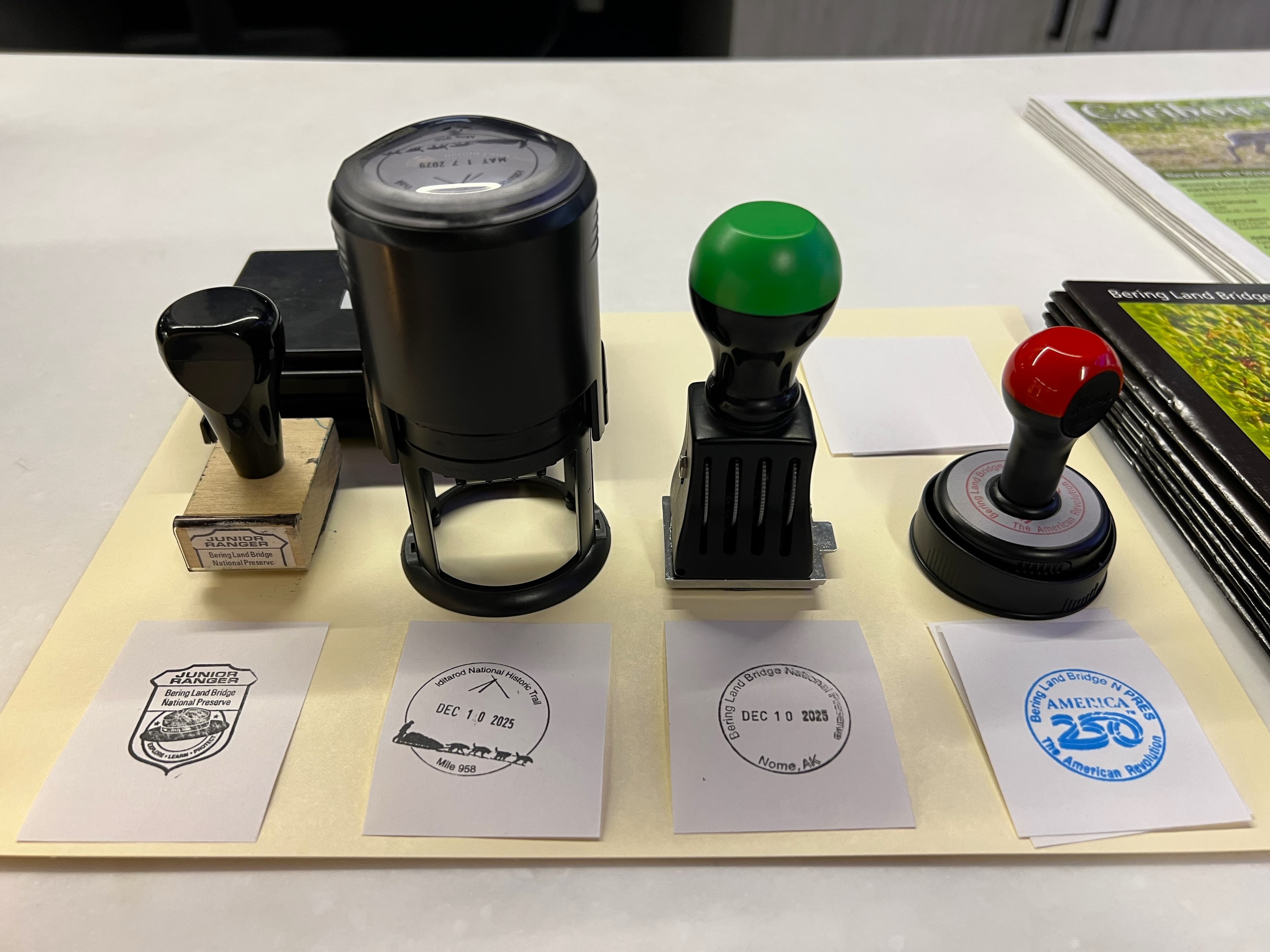 Four rubber stamps lined up with examples on paper squares beneath them.