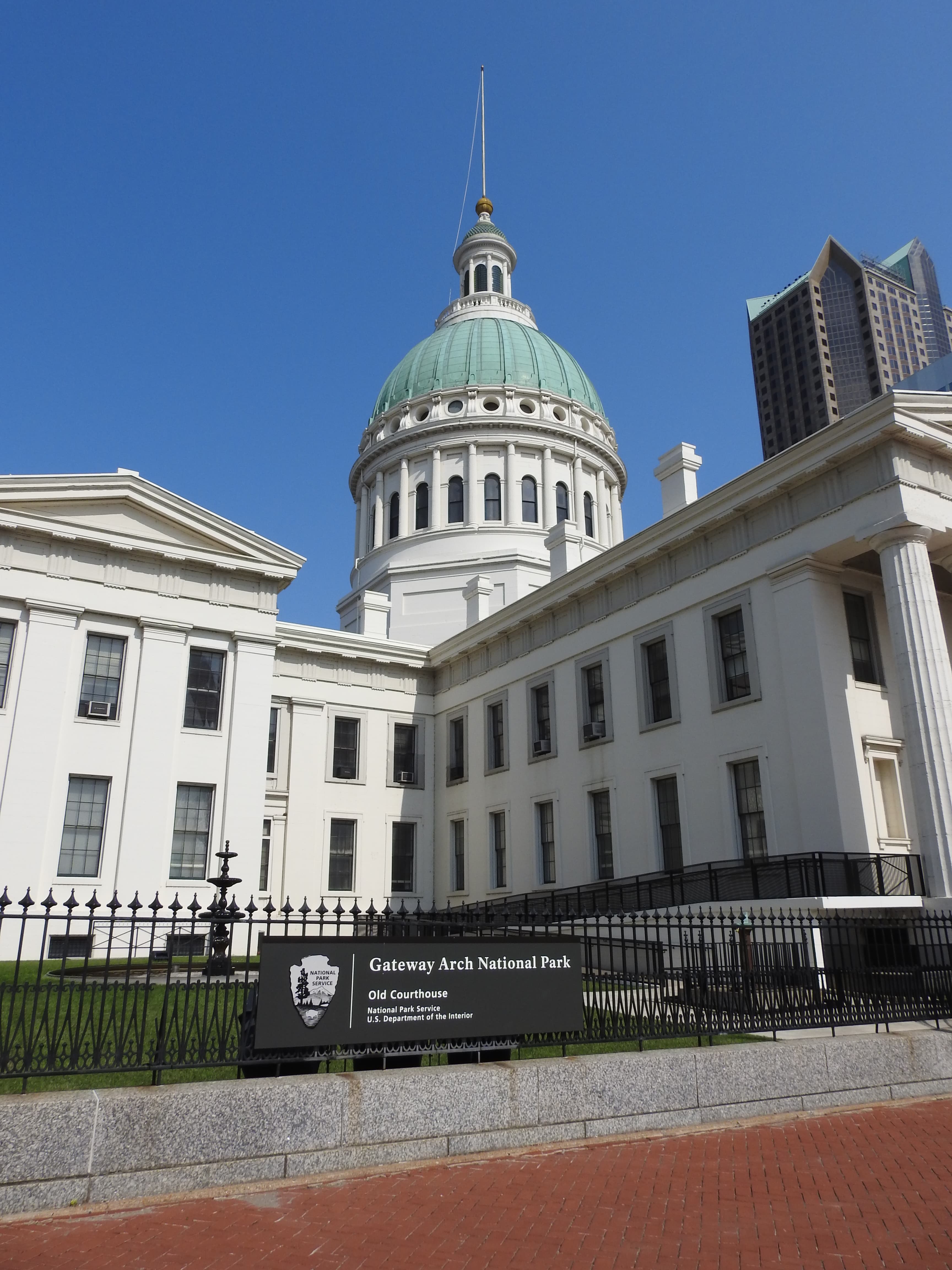 A white Greek Revival-style building with a green dome