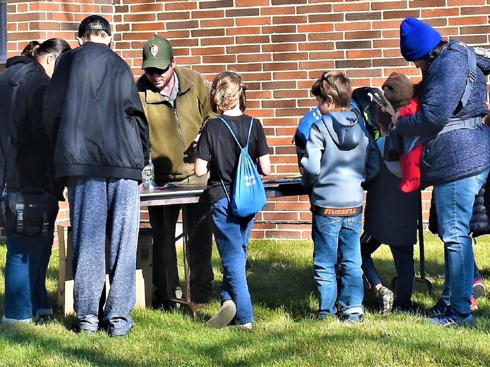 A ranger at a table outside with families