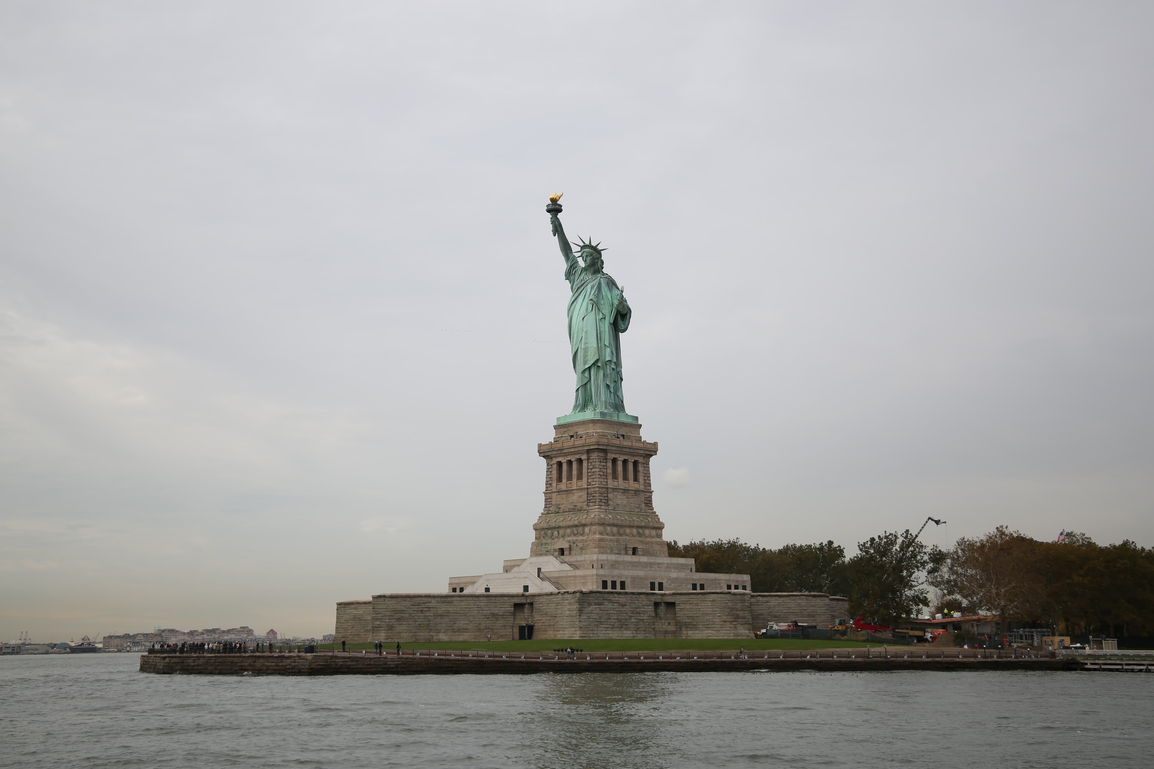 A view of the Statue of Liberty and Liberty Island from the water.