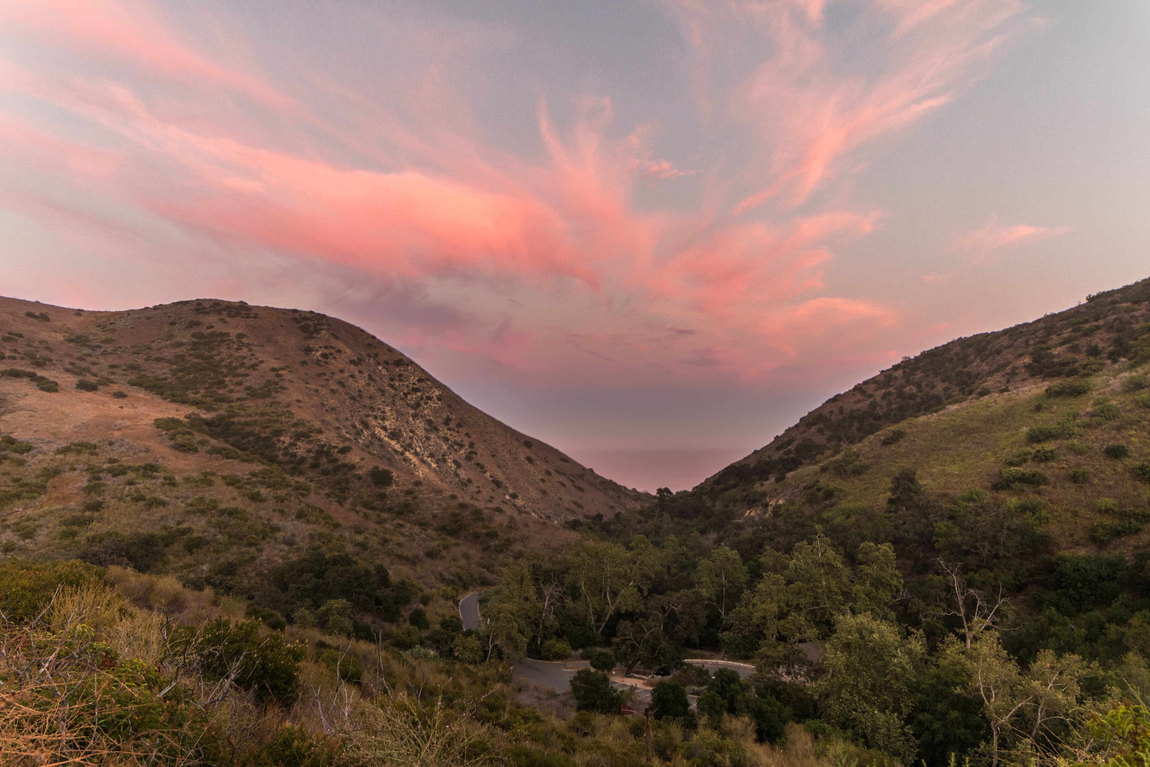 Pink sunset over the ocean from a view within Solstice Canyon.