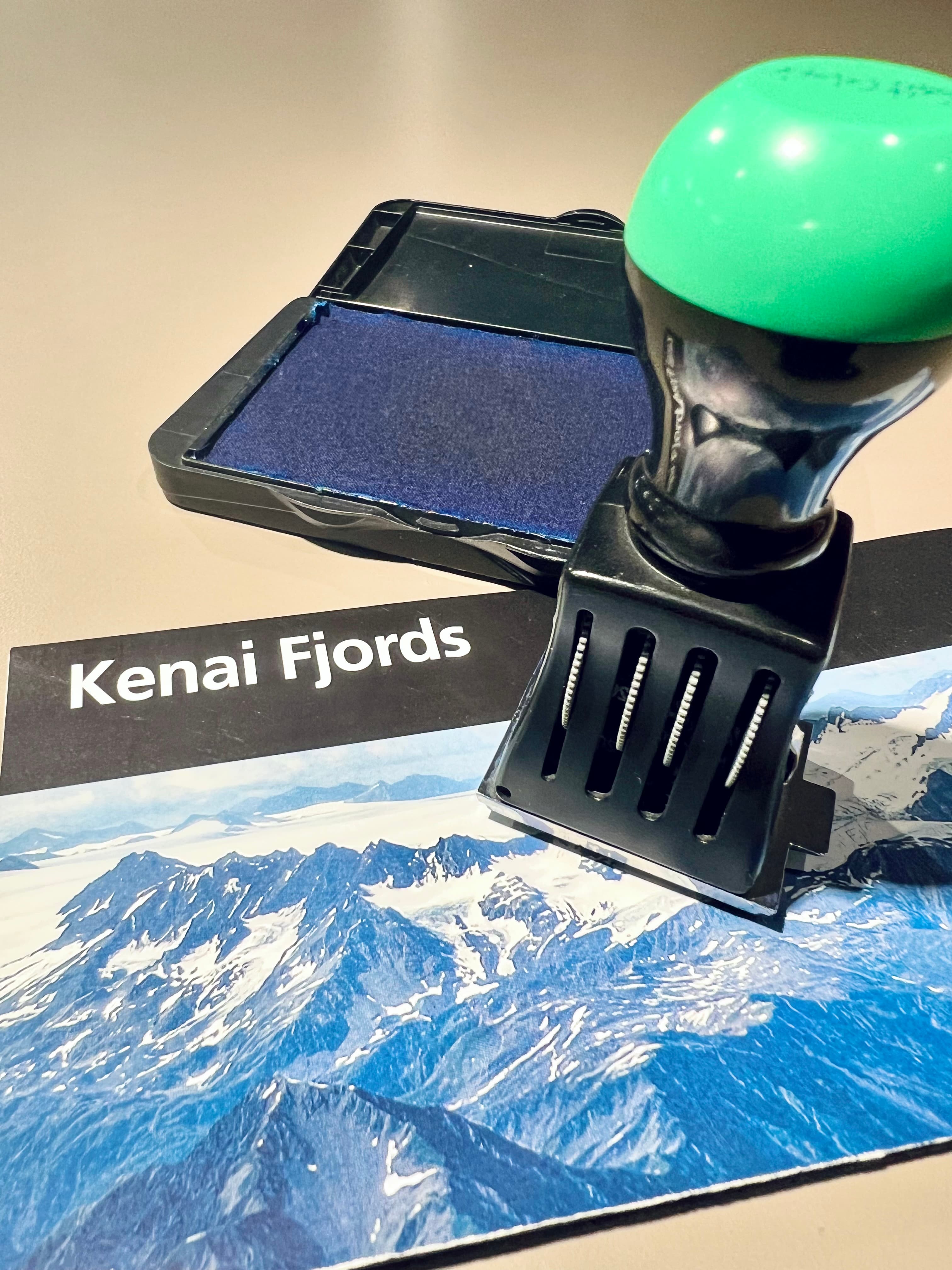 A park cancellation stamp on top of Kenai Fjords brochure