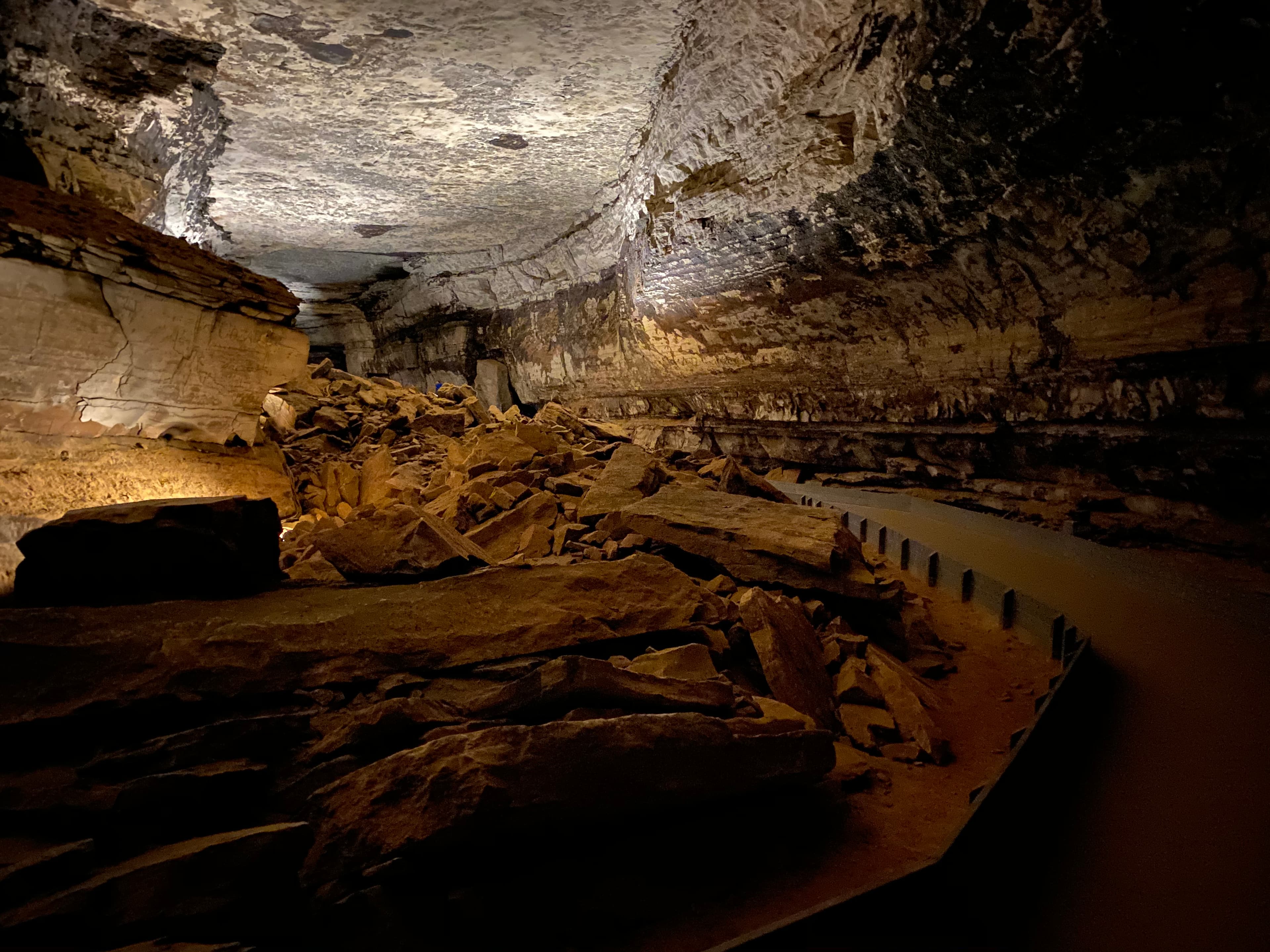 A large cave passage with a paved trail on the right side.