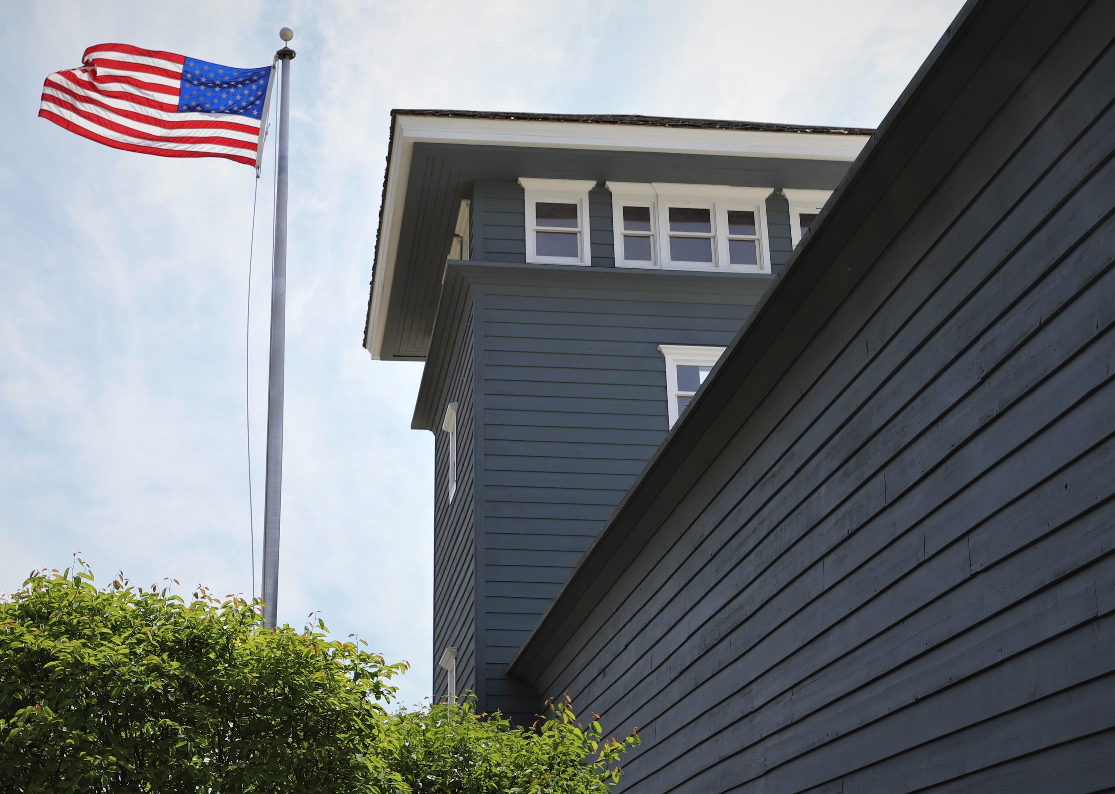 A american flag next to a tall blue buidling