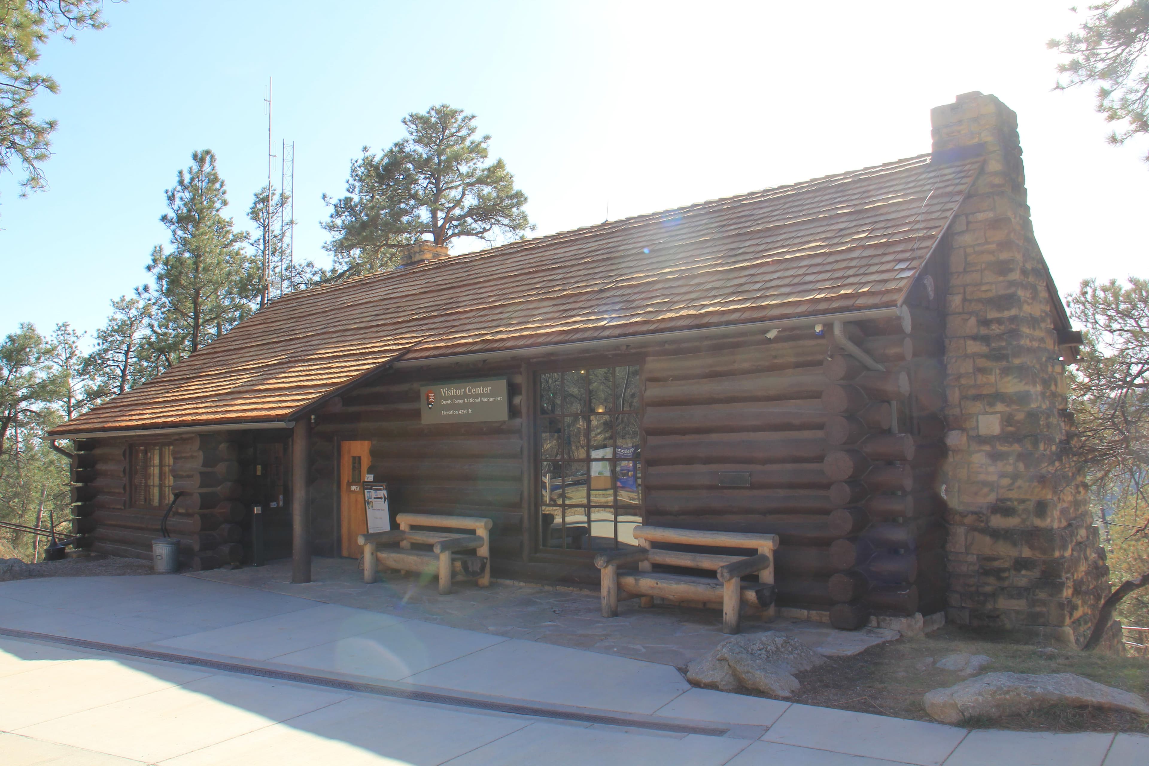 A wood cabin building with a stone fire place on one side.