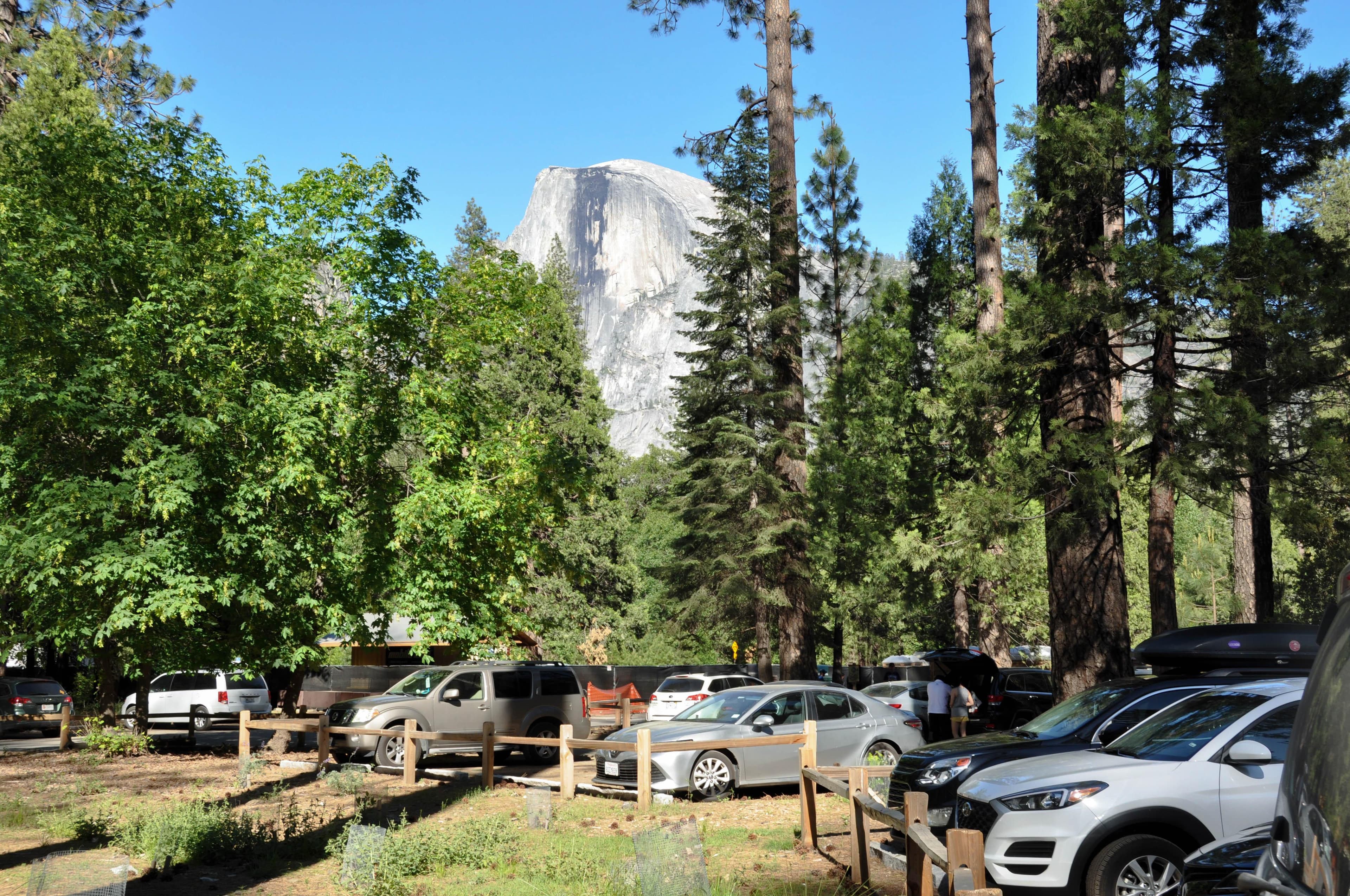 cars in parking area with Half Dome in background