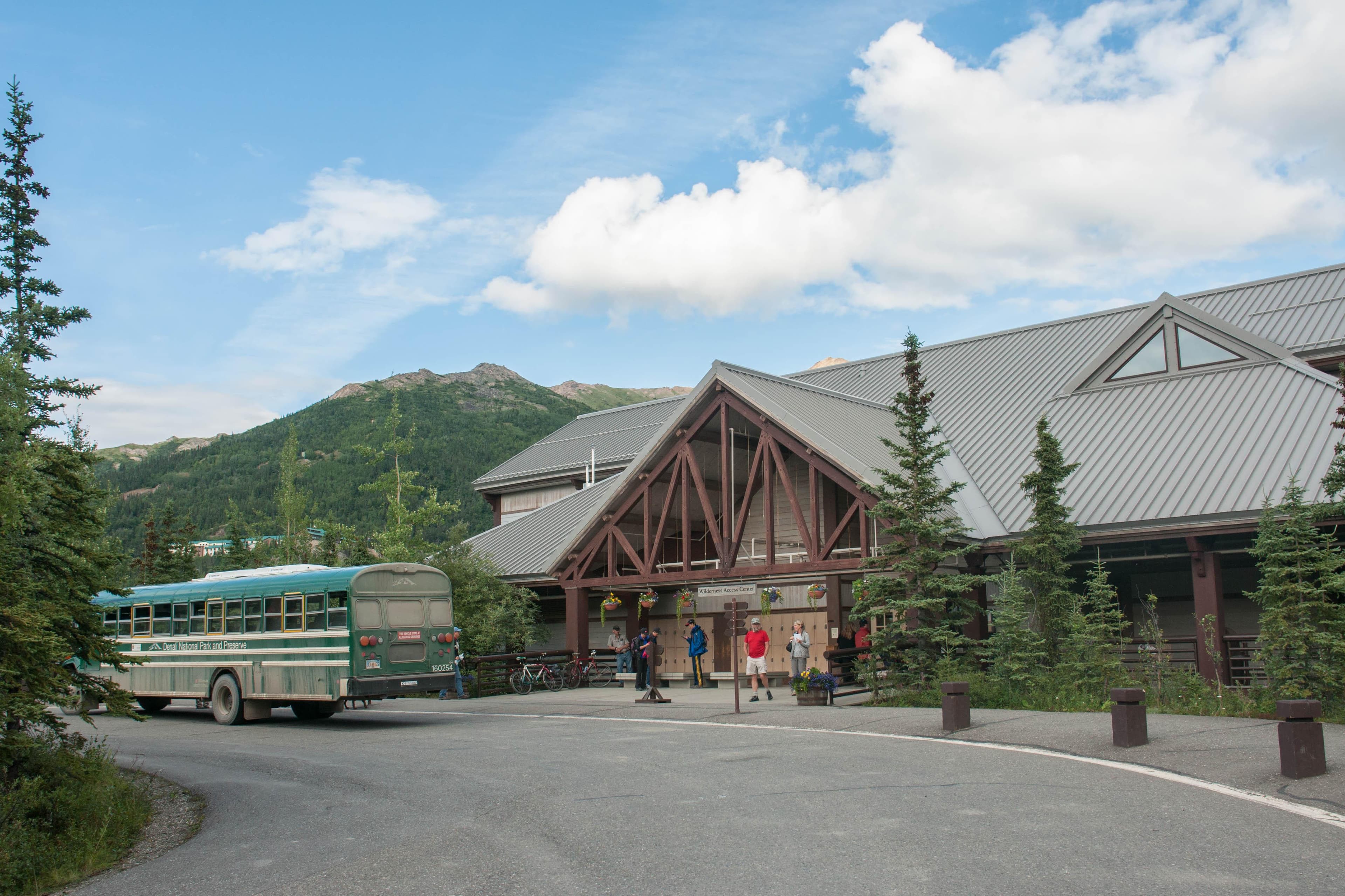 a bus parked outside a large building in a forest