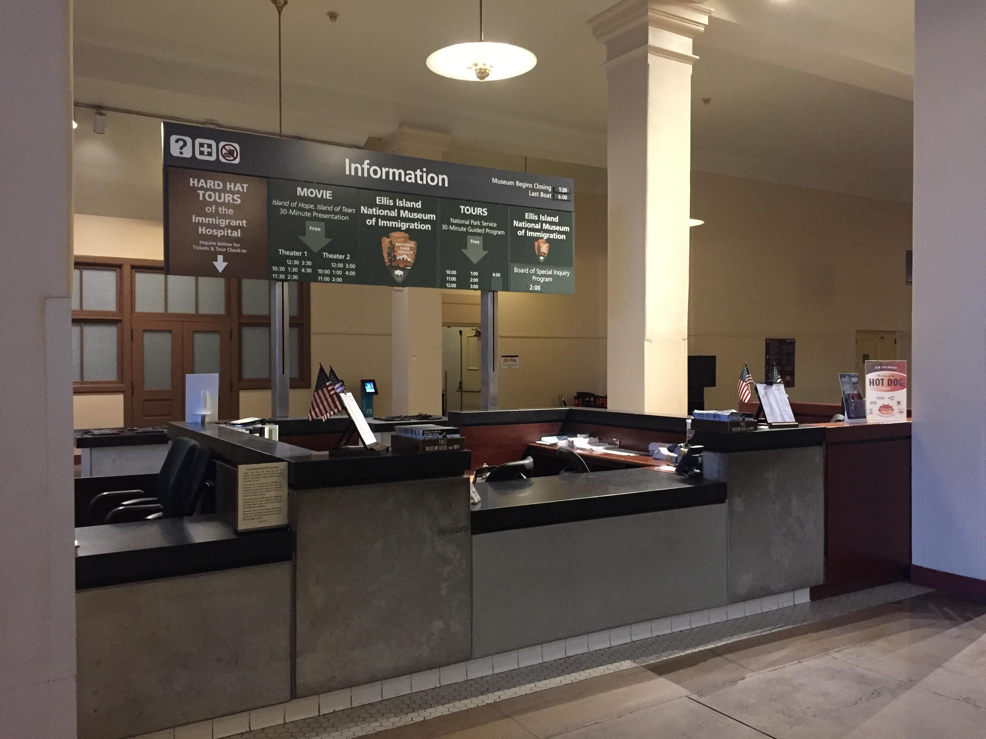 A view of the Ellis Island Information desk with an informational panel behind.