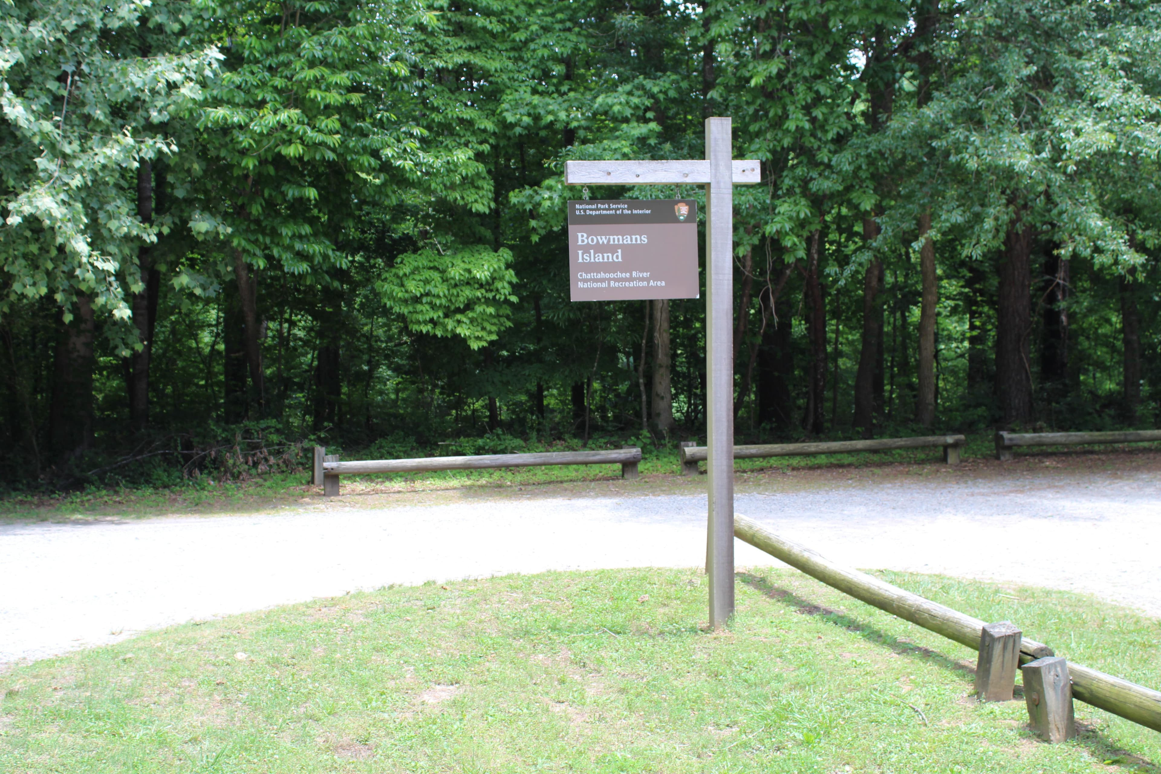 Entrance sign hanging from wooden post with the park and unit name.