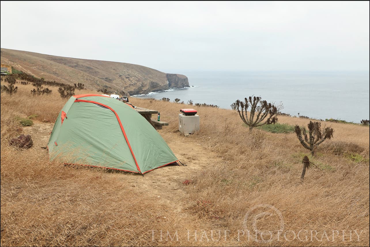Small tent perched on bluff overlooking the ocean.