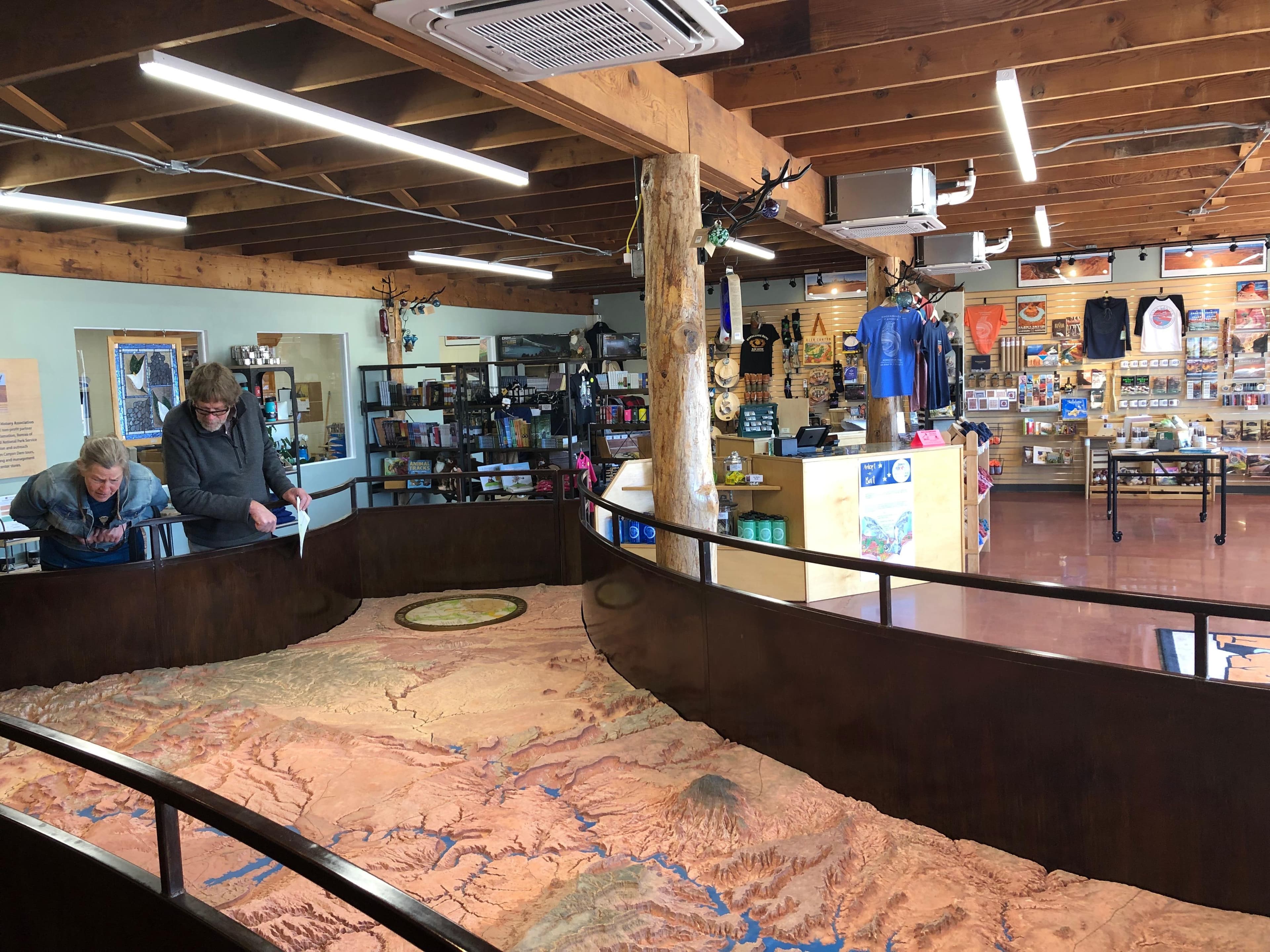 Two people lean over large relief map