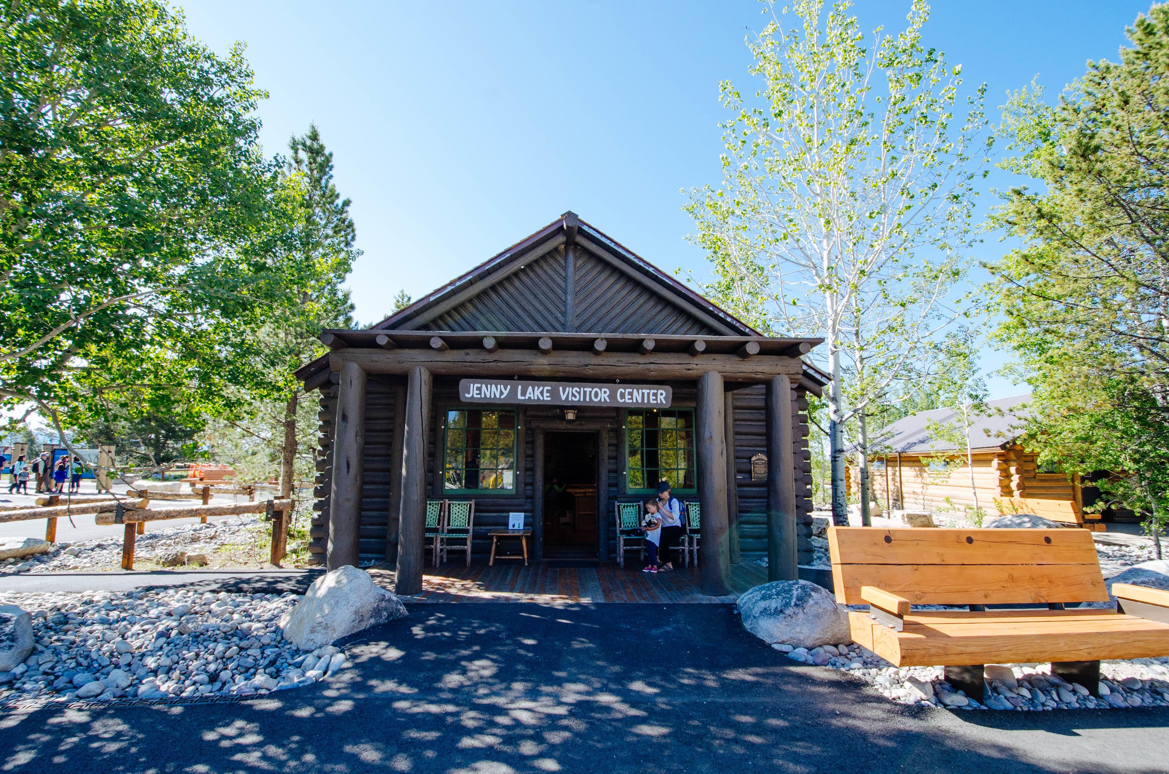 Log building with inviting covered porch. Information signs and benches are outside.