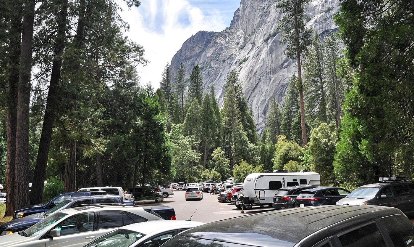 Cars parked in a full Yosemite Falls parking lot.