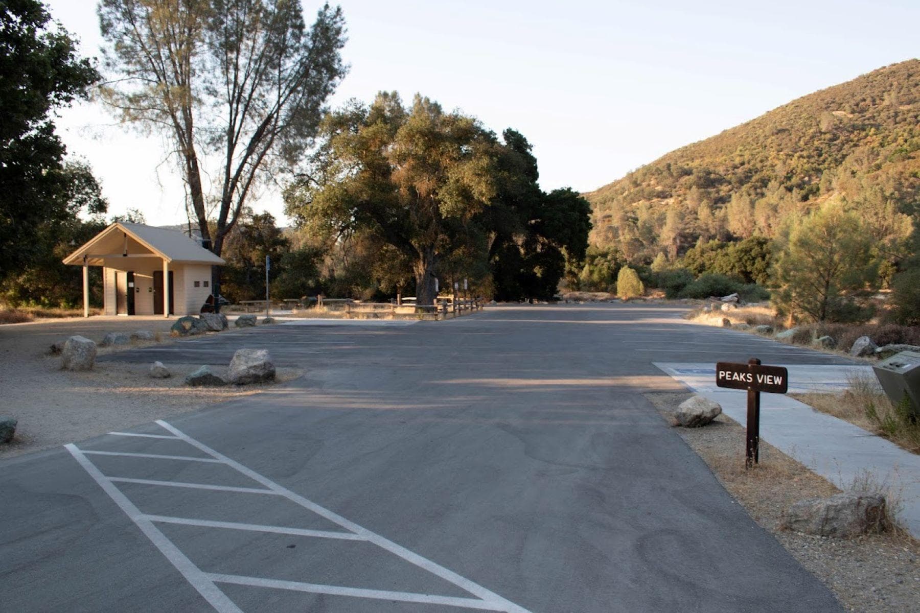 Paved parking area located near a seasonal stream in a rolling landscape of Oaks and Grey Pines