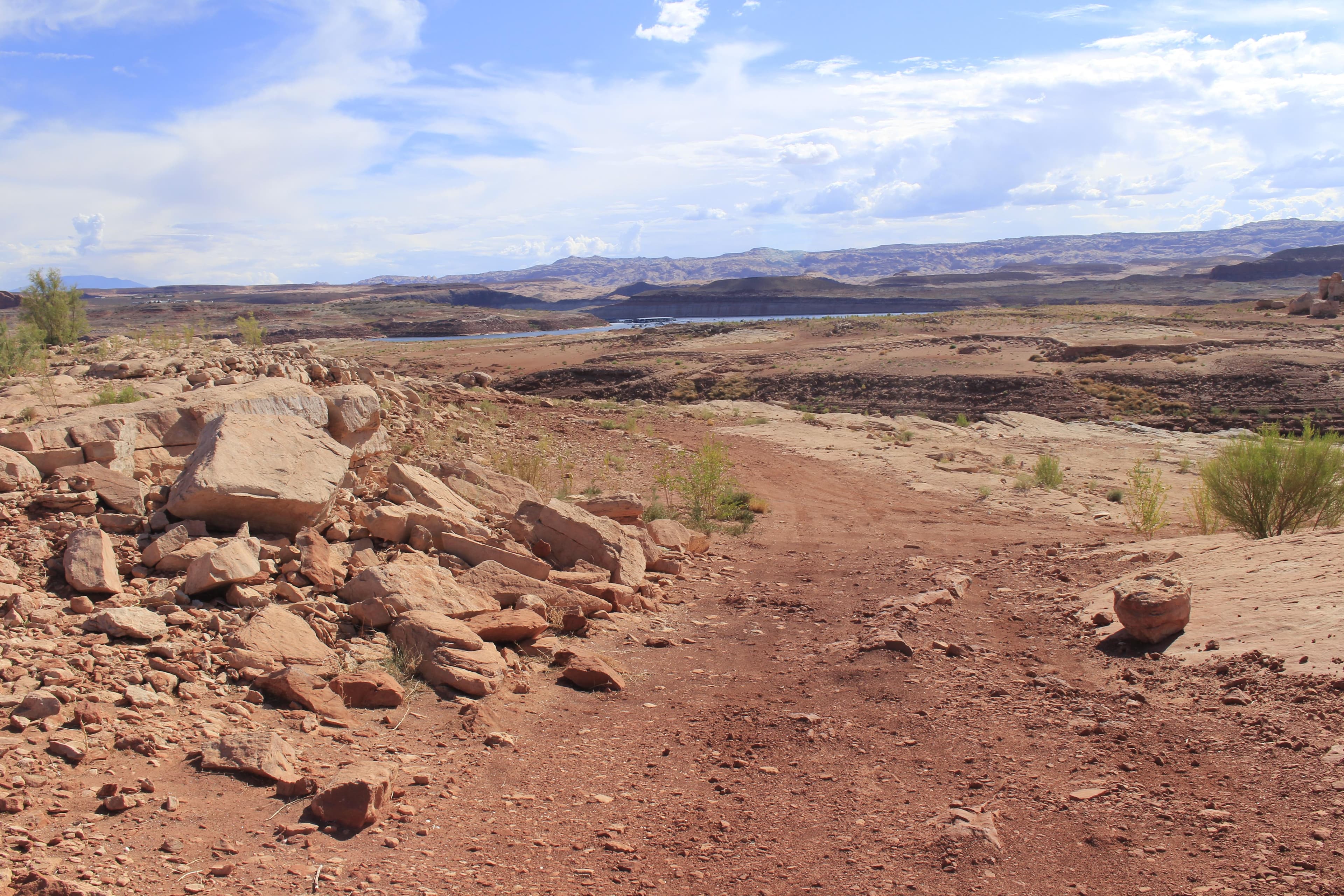 Red sand and sandstone features. Dark mountain in the background.