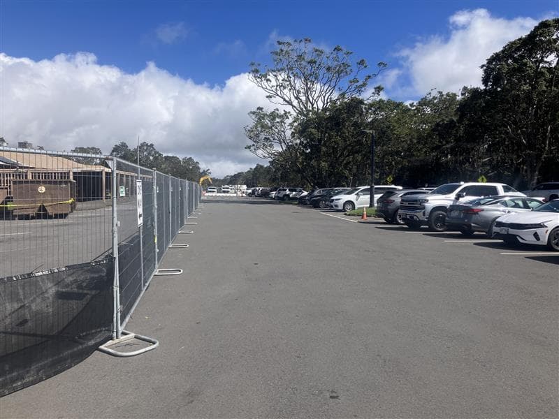 Cars parked near fencing for renovation