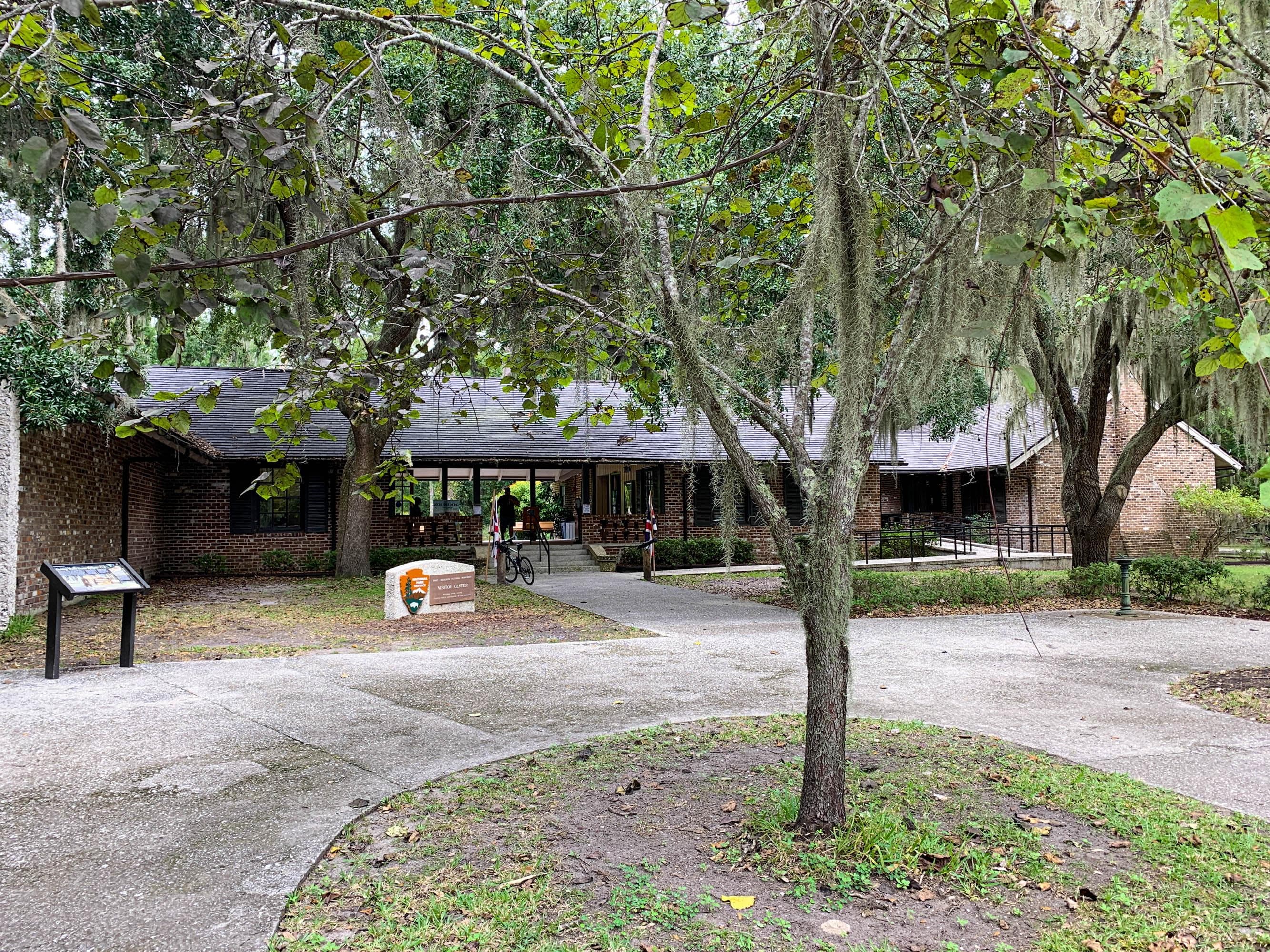 Brick visitor center with trees in front