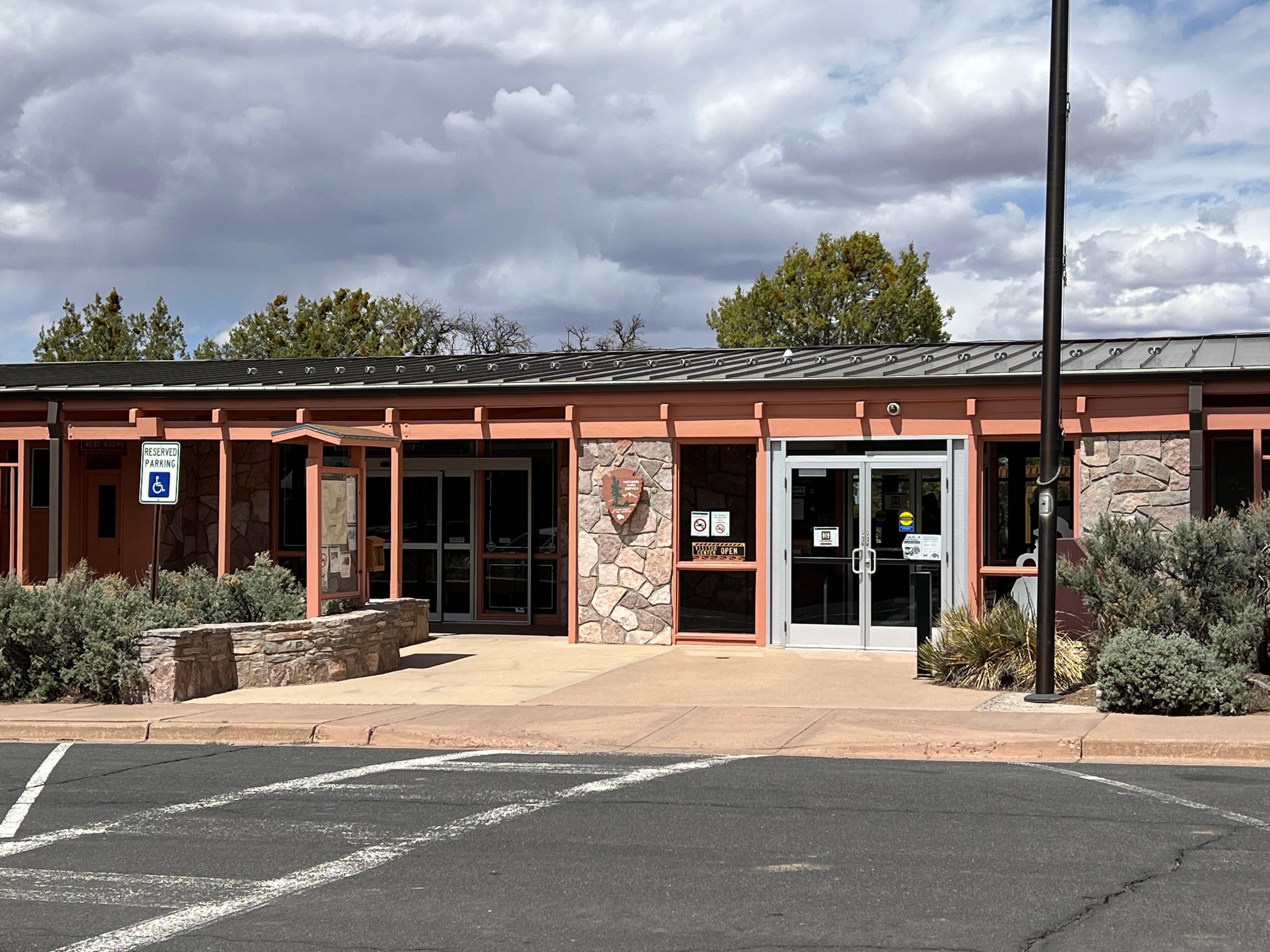 A parking space, sidewalk, and one-story building with doors.