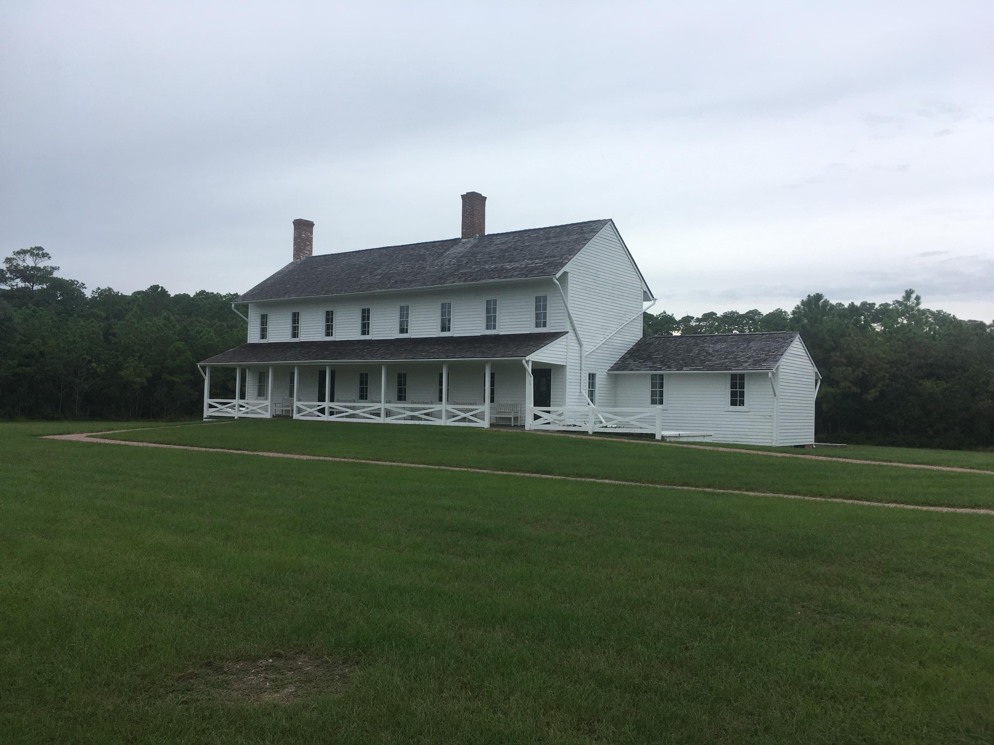 A white two story building with a covered porch