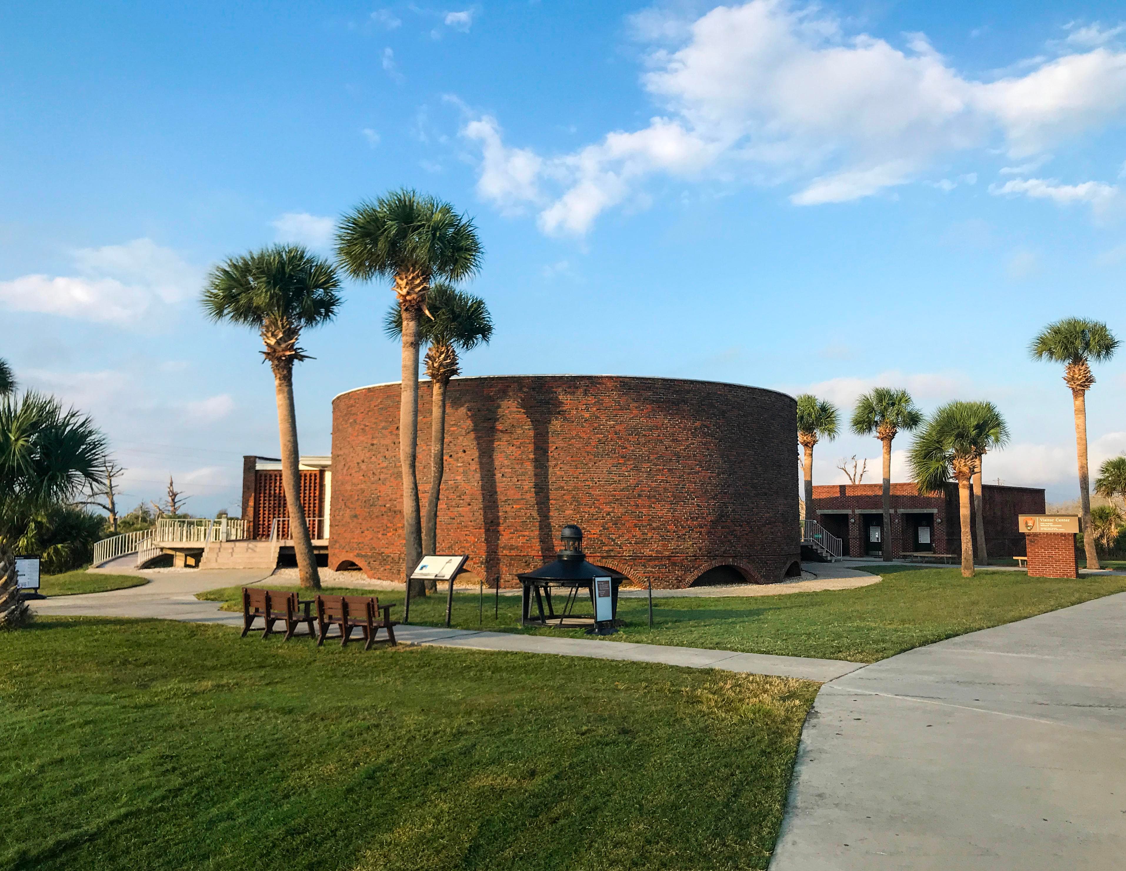 A view of the round masonry visitor center in the morning light.