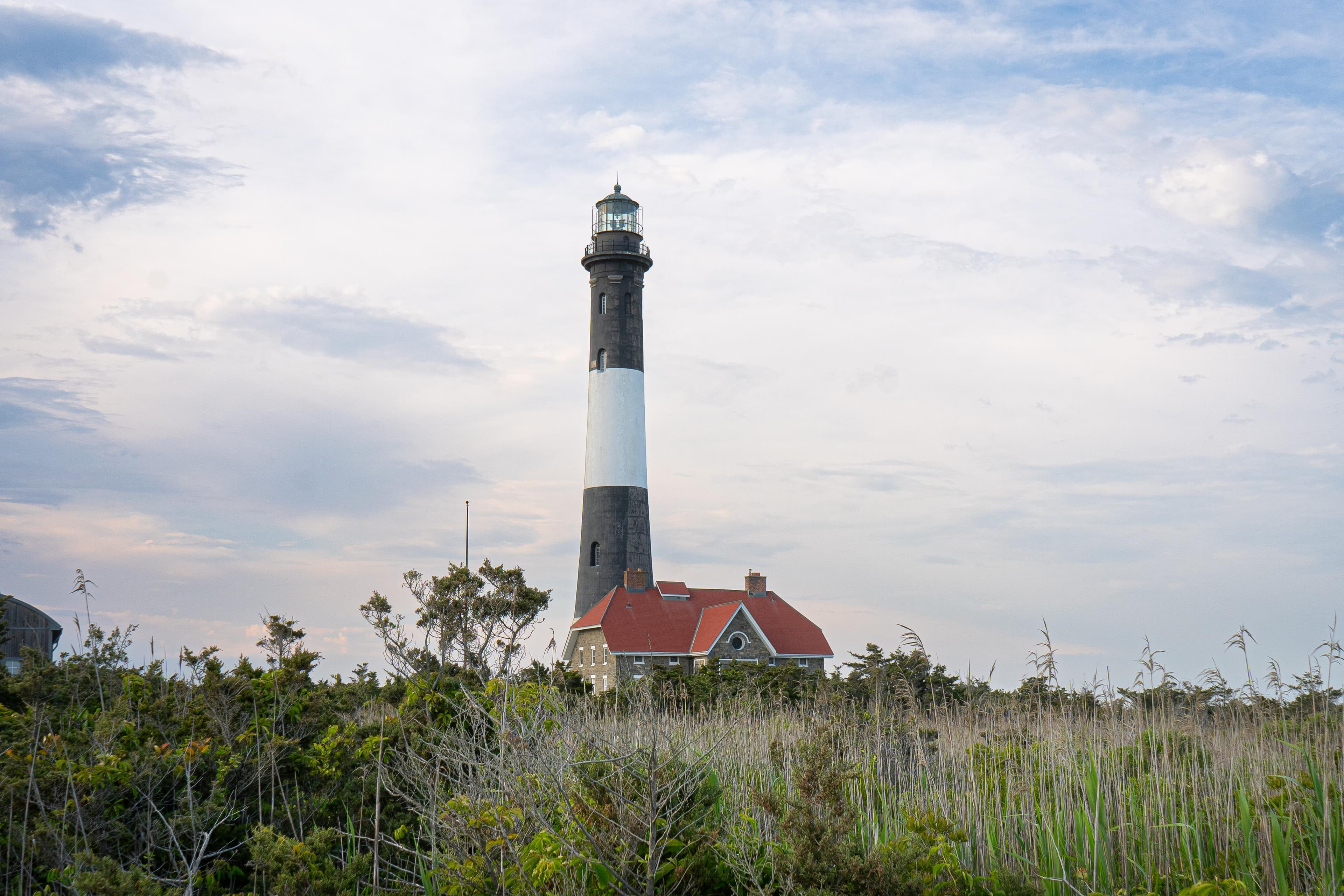View of a black and white striped lighthouse at dusk.