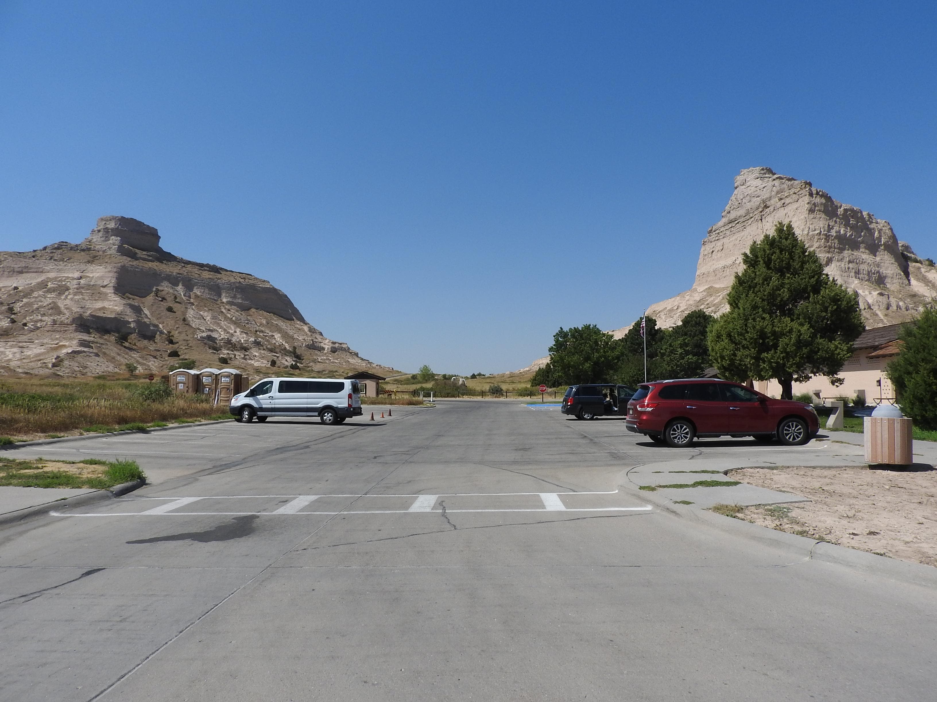 A parking area with distinctive rock formations in the background.