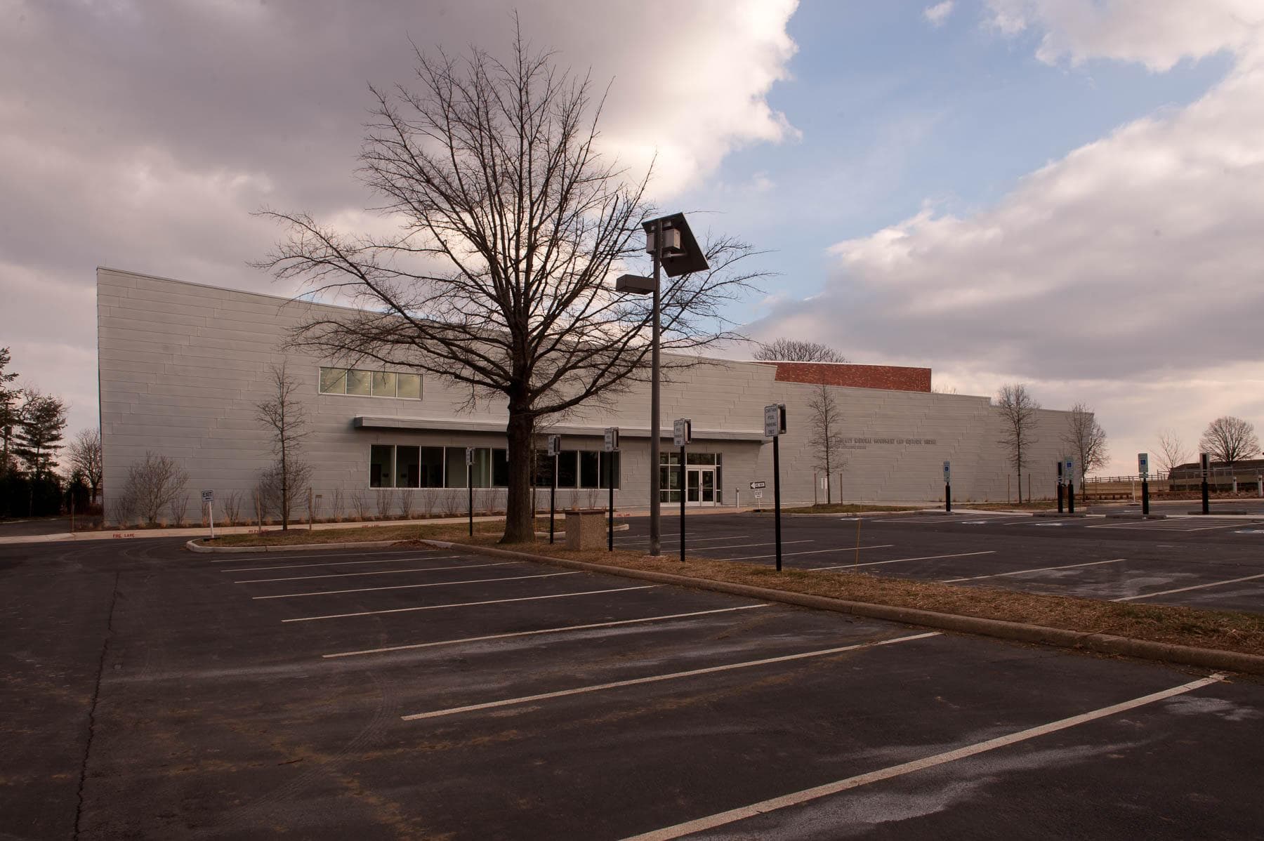 An empty parking lot in winter with the Fort McHenry visitor center in the background.