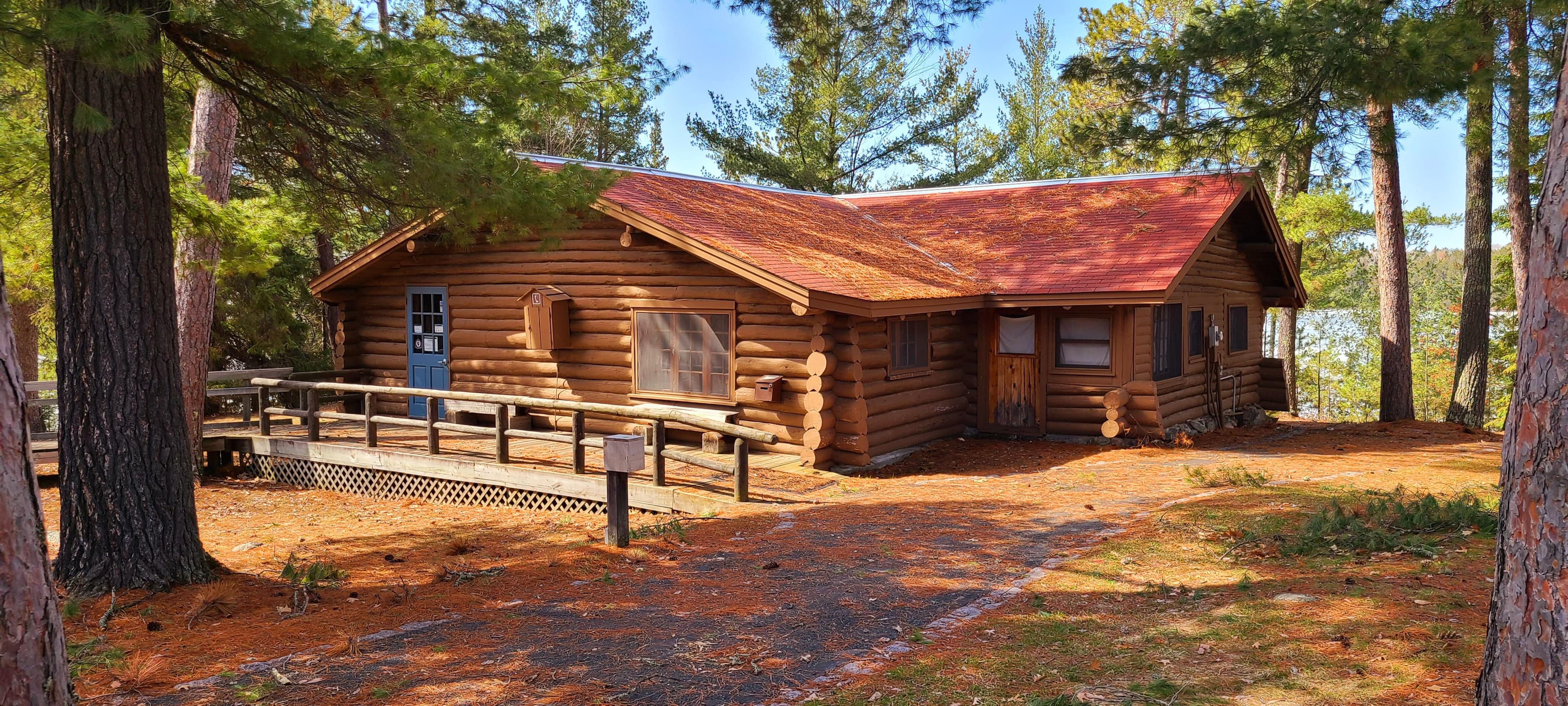 A pathway leads up to a brown log cabin.