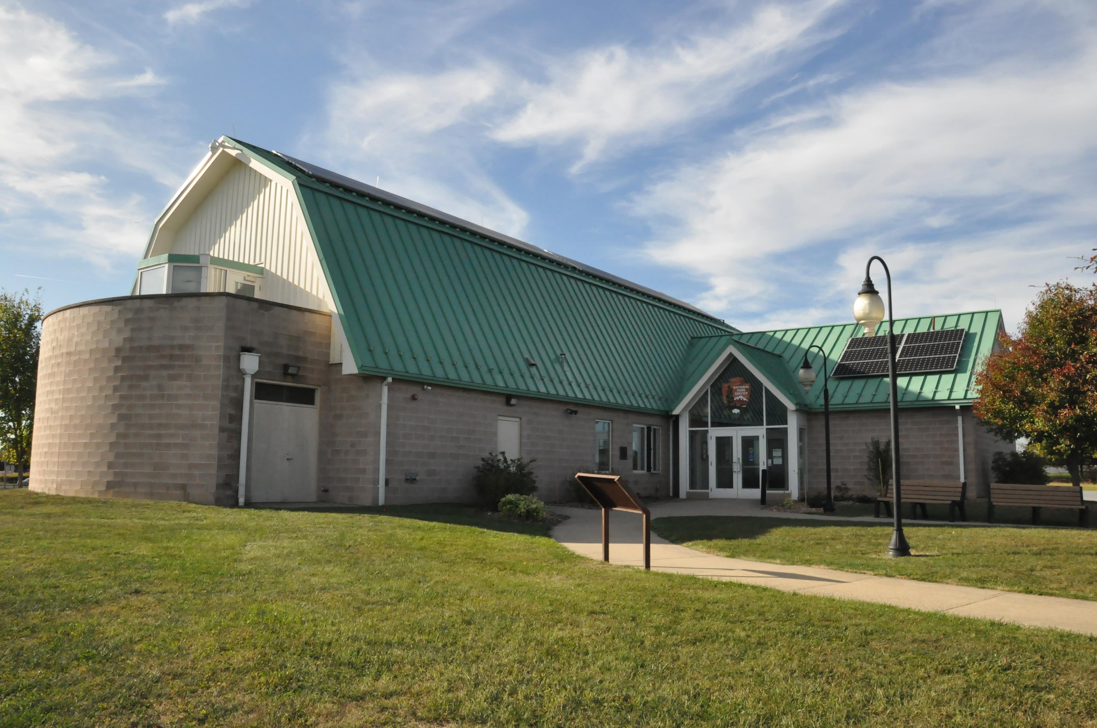 A classic barn shaped building with a green roof.