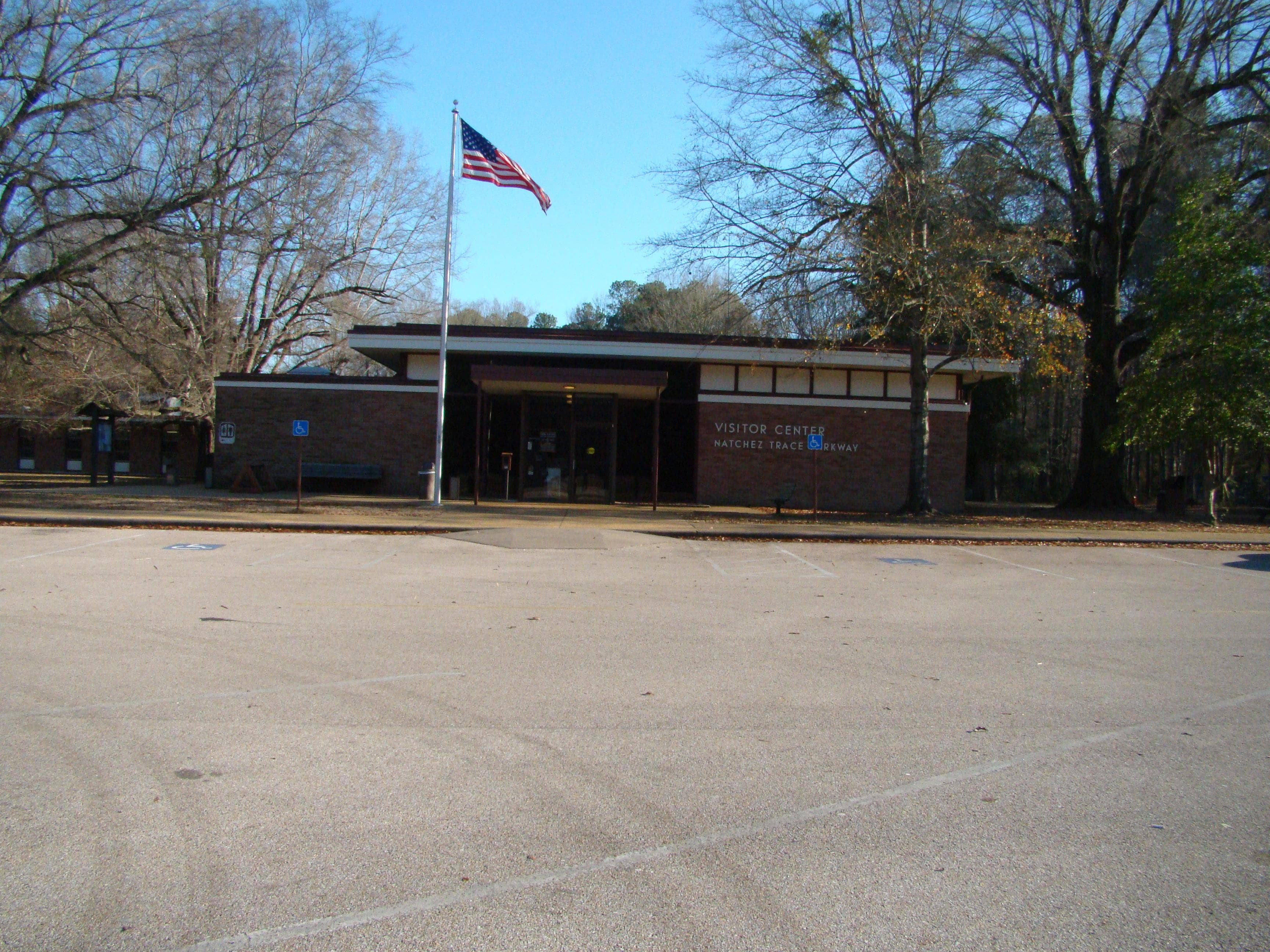 red brick exterior of the Parkway Visitor Center. Flag atop flag pole in front of building